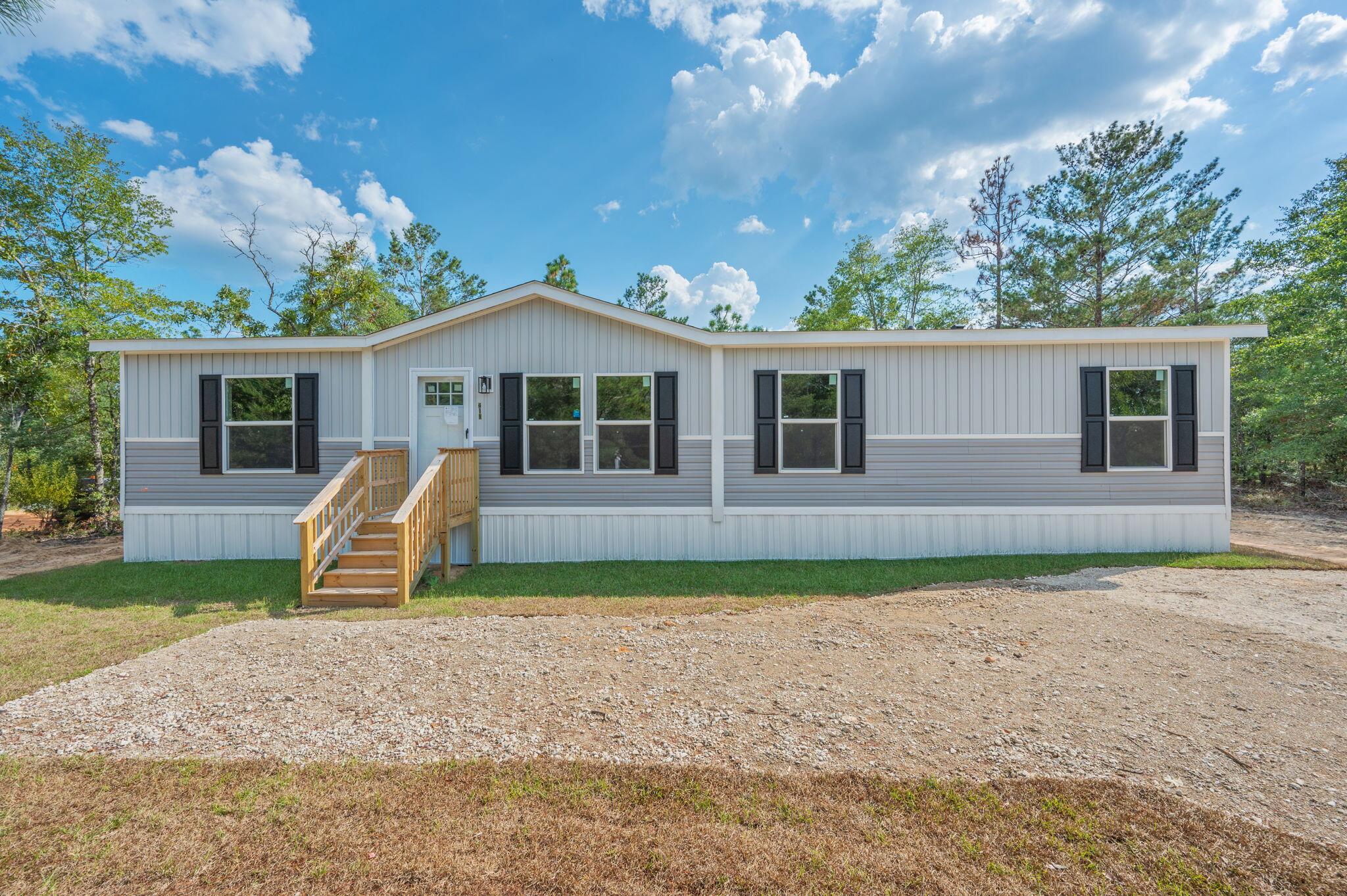 Be the first person to live in this brand new 4 bedroom, 2 bathroom manufactured home nestled on a spacious quarter-acre lot. This property features an inviting back porch--perfect for morning coffee or relaxing evenings outdoors. Inside, this home is unlike other manufactured homes with an upgraded kitchen including stainless steel appliances and vent hood, a french door refrigerator and custom color cabinetry. Off of the kitchen is a coffee bar and laundry room. The split bedroom floor plan offers privacy for the primary suite. The beautiful green cabinet color flows from the kitchen into the master bathroom where there is a double vanity and a walk-in shower. The large yard offers plenty of room for gardening, outdoor play, or future upgrades like a workshop or carport.