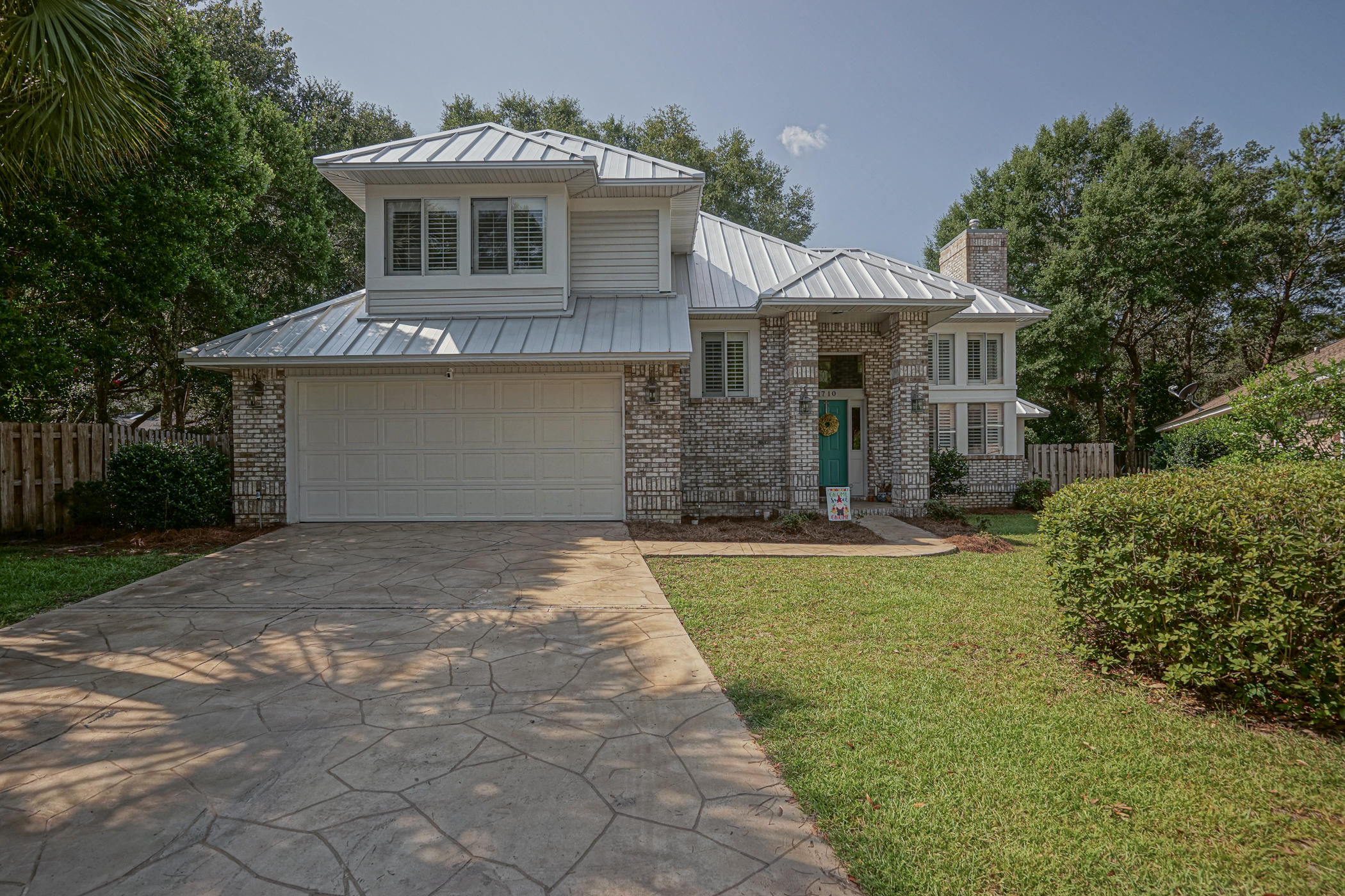 Gorgeous brick 4 bedroom plus office/sitting room in gated Parkwood Estates. Walk or bike the kids to top rated Bluewater Elementary school, wander on over to the Bayou for sunsets or fish in the numerous ponds, enjoy the sidewalks to walk to the neighborhood park with the kids and enjoy all Bluewater Bay has to offer with this stunning home. Nestled on a private cul-de-sac this striking home features a new 50 year seamless metal roof, landscaped fenced yard and upgraded stamped concrete driveway and patio. You are greeted with beautiful real hardwood floors throughout, soaring ceilings with designer light fixtures and fans, plantation shutters, wine fridge and granite counters with ample cabinets. An office used as a sitting orchid room (perfect playroom), dining room, CLICK MORE>>