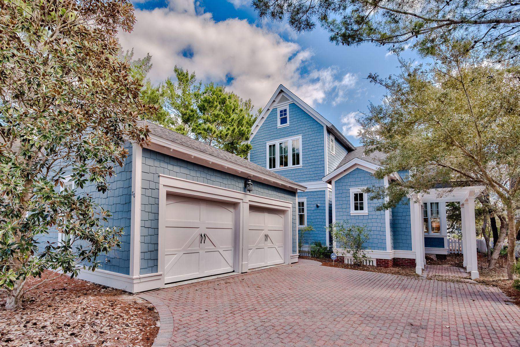 Forget cookie-cutter architecture. This charming coastal cottage in WaterSound Beach has instant curb appeal with its Gulf-blue shingle-clad exterior behind a white picket fence. A paved driveway sweeps up to the two car garage terminating in a footpath to the front porch and entrance. Step inside to find gleaming wood flooring, traditional paneled wainscoting, new lighting and a warming fire in the fireplace. Filled with artworks and handpicked accents, it's a room for sharing happy times with family and friends. The open floorplan flows from the well-lit dining area into the gourmet kitchen. Chefs will look with envy at the range of white Shaker-style cabinets, stainless appliances and black granite counters.