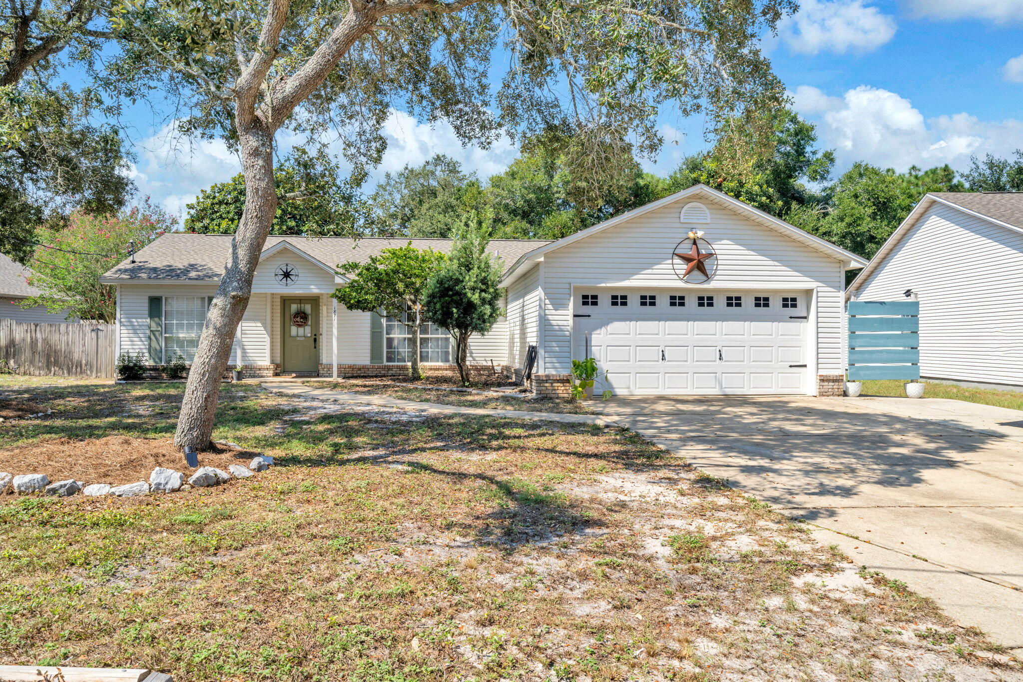 This 3/2 Gulf Breeze home has lots of extras! If you are looking for a home with a large, private yard to enjoy then your search is over! This 3/2 home has a functional open-concept layout with split bedroom floorplan. Warm and inviting wood-look tile adorns the common areas while the bedrooms have brand new carpet. The primary room is spacious and it's en-suite has a deeply relaxing vibe with bamboo countertop and bowl sinks. Living room has a beautiful flagstone wood-burning fireplace. Huge screened-in porch overlooks the highlight of the home, the massive yard! There is a deck with built-in fireplace, a grill area, treehouse and two outbuildings with power. One is an insulated, temperature controlled shed with storage bunks and built-in ladder. The other is currently housing 20 of the best egg-laying chickens you'll ever lay eyes on! Attached to their roost is an enclosed run. Get a head start on your homesteading dreams or they can be rehomed before closing and you can convert the second shed to fit your needs. The property line extends beyond the fenced yard where you'll find another fire-pit and a disc golf basket set up for practice. Over a half acre of property primed for entertaining! Located just down the street from the fire department and a short drive to our coveted Emerald Coast beaches!