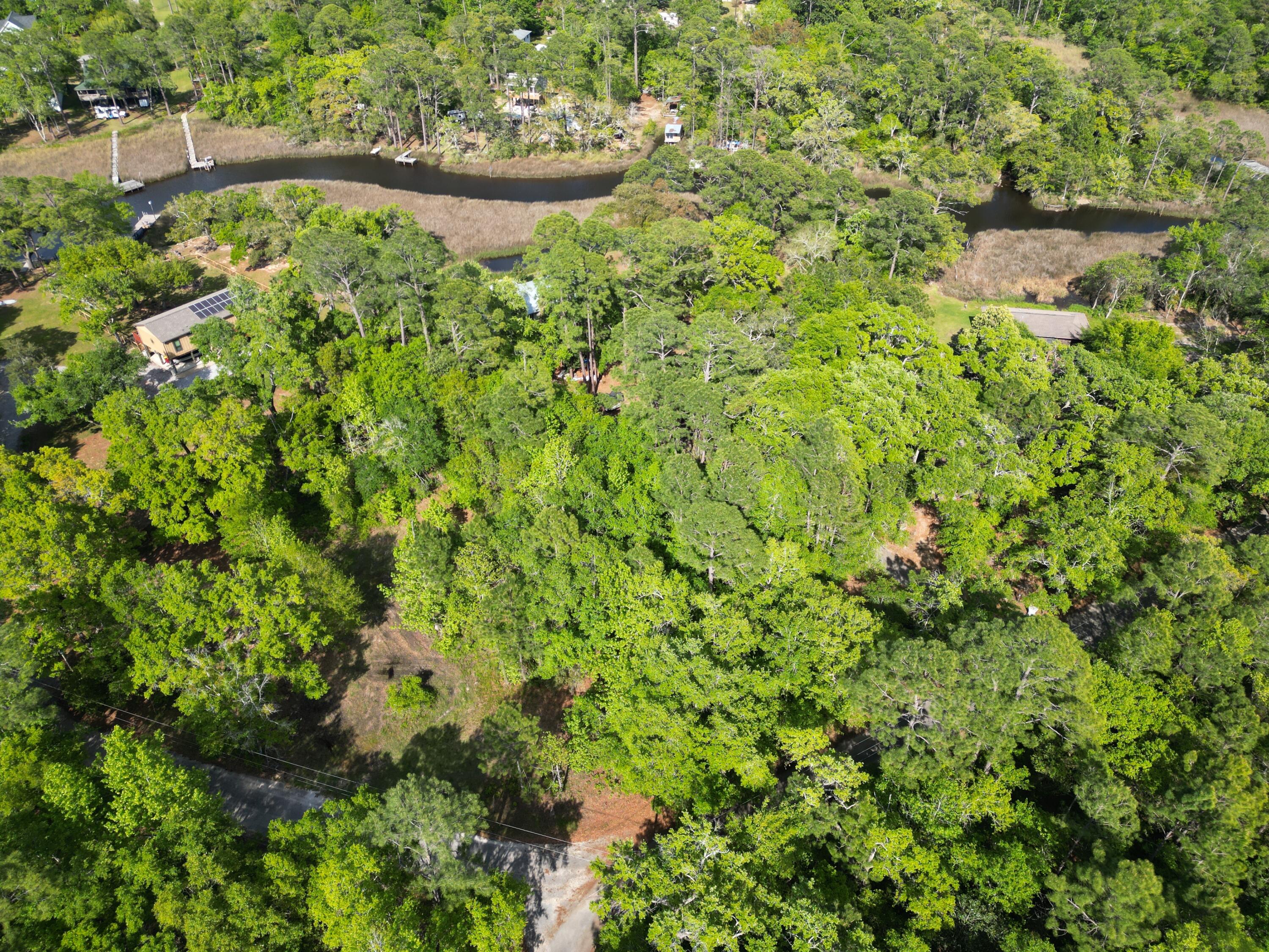 NO WETLANDS per GIS map. Beautiful .33 acre corner lot. Partially wooded and cleared. perfect parcel to build a single family home or MODULAR home. SETBACKS are F 25' R 25' s 15'.......NO mobile homes, or duplexes allowed. Zoned R1. Although not directly on the Bayou, this corner lot provides a serene view filled with the view of the water, many species of full grown trees and flowers, and is within walking distance to the Bayou. See photos for all pertinent information per the GIS map . AE flood Zone, no wetlands, soils, elevation, etc.... NO studies have been conducted