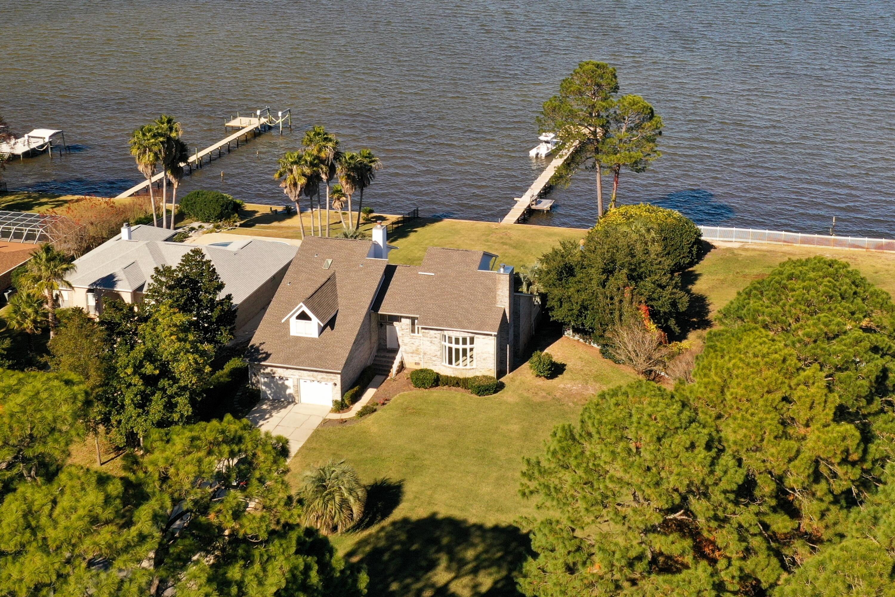 Situated on an oversize lot at .64 acres with 80 feet of waterfront, you will have plenty of room to enjoy the beautiful weather Florida is so well known for. Keep your boat and water toys docked at your own newly built private pier. This spacious 3031 sqft foot home has breath-taking views overlooking Pensacola Bay throughout the entire residence. With 3 bedrooms, including 2 master suites (one on each level), and a half bath - entertaining friends and family on the waterfront will always be something to look forward to. Fireplaces are the center piece of the den and family room. This home received a brand new roof in 2021. And you can set your mind at ease with being a full 12ft above sea level.