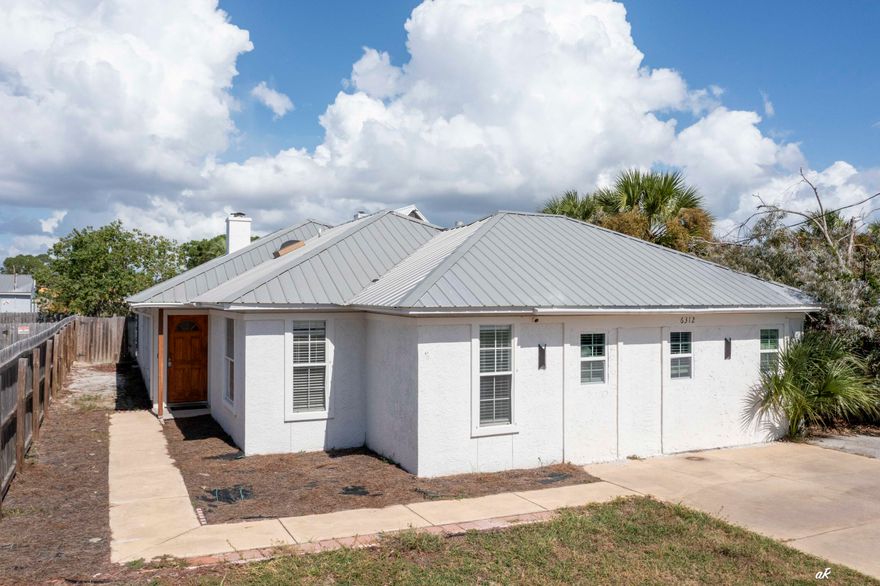 Just steps from the beach, this beautifully updated coastal home offers the perfect blend of comfort, style, and investment potential. Inside, you'll find a bright open floor plan with luxury vinyl plank flooring, modern fixtures, and an inviting layout ideal for entertaining or relaxing after a day by the water. The kitchen boasts sleek countertops, updated appliances, and plenty of storage, while each bedroom provides a peaceful retreat with beachy charm. Outside, enjoy the ocean breeze from your private patio or take a short stroll to the sand and surf. Whether you're looking for a full-time residence, a vacation getaway, or a high demand short-term rental opportunity, this property delivers it all. With its prime location, modern updates, and income producing potential, this home is truly a rare coastal gem.