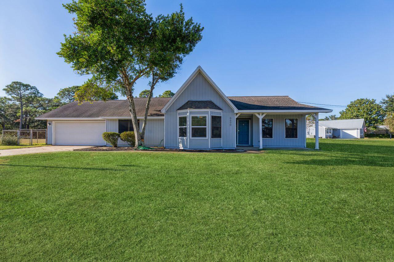 Welcome to this expansive .63 acre corner lot home in Holley By The Sea! Just one turn off Hwy 98 makes for ease of entrance and exit. Upon entering the home you will be drawn to the cathedral ceilings with handsome wooden beams; highlighting the floor to ceiling wood burning fireplace that separates the living room from the kitchen area. The open, upgraded kitchen features stainless steel appliances, tile backsplash, and soft close cabinets on center counter height island that seats 3. Vinyl plank flooring in main living areas as well as in bedroom one; new carpet in remaining bedrooms. Floor to ceiling tiled large master shower with double glass door. Updated second bath with tub. New windows to be installed Dec. 2, freshly painted interior and exterior; this home is ready for you!