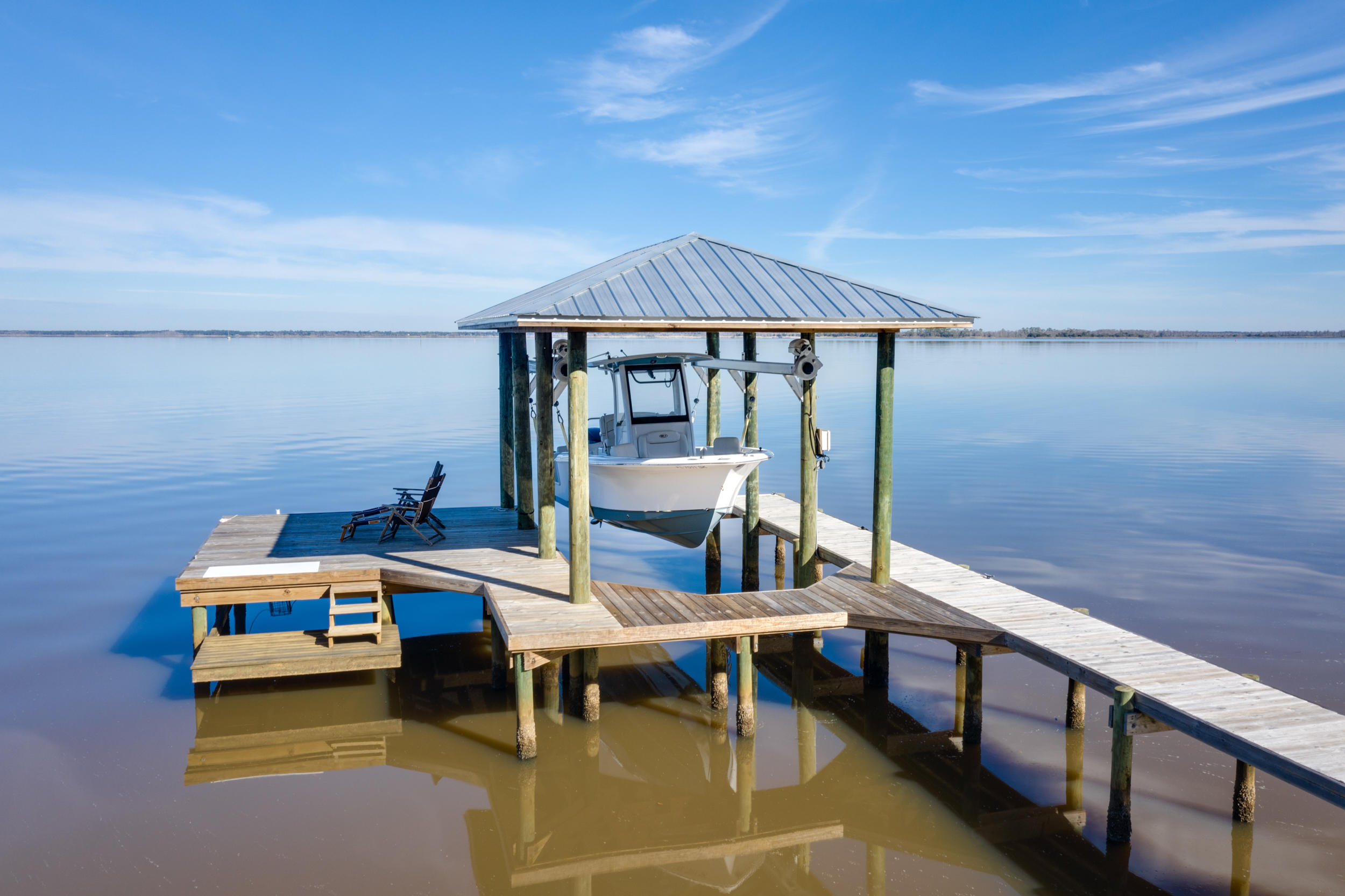 Completely renovated in 2019, this Geoff Chick redesigned bayfront modern farmhouse is full of character and charm and 100 feet on the Choctawhatchee Bay. Located in Point Washington on a quiet street with beautiful oak trees and gorgeous sunrises and sunsets, this home features a large heated pool and spa, covered boat lift with dock and swim/paddle platform, outdoor covered porch and large lush lawn. With Bevelo gas lanterns, painted white brick and hardiboard siding and shutters, this 3400 sq ft home has a great layout of 4 bedrooms and 4 full baths and living area (living room, den, dining room, kitchen and study) all located on the main floor. There is even a flex bonus room upstairs that can be used as a workout room, playroom or office.