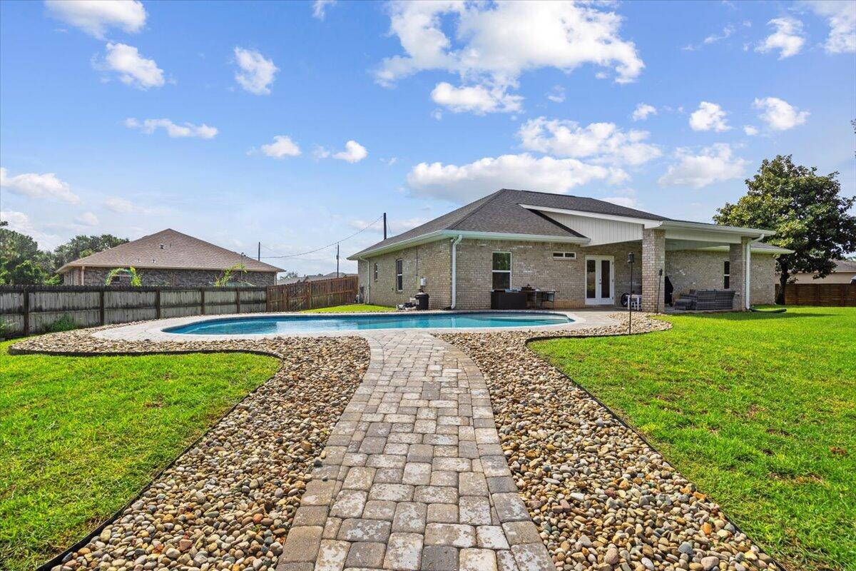 Custom-Built Energy-Efficient Home with Luxury Upgrades! Recently appraised for $545k! Step into modern comfort and sustainable living with this Custom-Built Energy Efficient Earth Cents home, designed to impress while saving on utilities and insurance costs. This residence boasts paid-off solar panels by Atlantic Key Energy/Sunergy, custom fabric hurricane protection, & an insurance-saving hip roof with architectural shingles.Inside, you'll find a bright, open layout with wood grain tile flooring in the great room, dining, kitchen, and all wet areas for easy maintenance. The gourmet kitchen is a showstopper, featuring high-end, staggered cabinets with soft-close doors/drawers by Distinct by Design, crown molding, under-cabinet lighting, granite countertops, a modern tile backsplash , and a barrel ceiling crafted from reclaimed barnwood over the large granite island. The kitchen also includes an energy-efficient range, built-in microwave, dishwasher, brand new Midea refrigerator, and an under-counter wine cooler.
The 9' ceilings and tray ceilings in the primary bedroom and great room are accented with crown molding and LED can lighting. Energy-saving features abound: Low-E vinyl windows, water-saving toilets, a 14 SEER HVAC system, and an electric vehicle outlet in the garage. The home is also wired for a whole-house generator and equipped with a full RING security system.
Double French doors open to a covered porch, 8' deep sparkling pool, complete with a sun lounging shelf, and a cozy fire pit- perfect for entertaining or unwinding in your own private retreat.
Additional highlights:
Ceiling fans in all bedrooms and great room
Custom interior doors with lever handles
Energy-efficient water heater
Modern rocker switches
Solar panel energy savings
This home truly has it all: style, comfort, and efficiency. Don't miss the chance to make it yours. Schedule your private showing today!