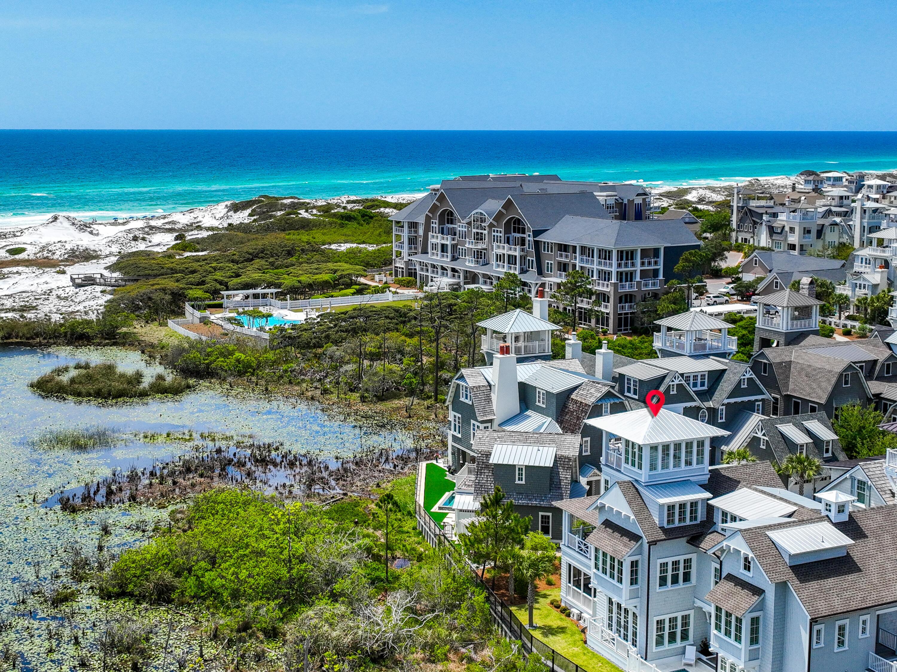 Nestled in the desirable Gulf front community of WaterSound Beach, this breathtaking home is situated on a sizable lot at the end of Compass Point Way. As you enter the home, you are welcomed by a large screened porch with a fireplace. The gulfs soothing waves can be heard creating a calming ambiance ideal for enjoying a glass of your favorite wine from your private wine room. Expand your entertainment space by sliding open the wall between the porch and main living area. Step through the front door to the expansive and open living area flooded with light from the wall of windows complete with a gorgeous gas fireplace and a charming dining area perfect for hosting guests or a quiet evening at home. Adjacent to living room, you'll find the gourmet kitchen including the Wolf and Subzero