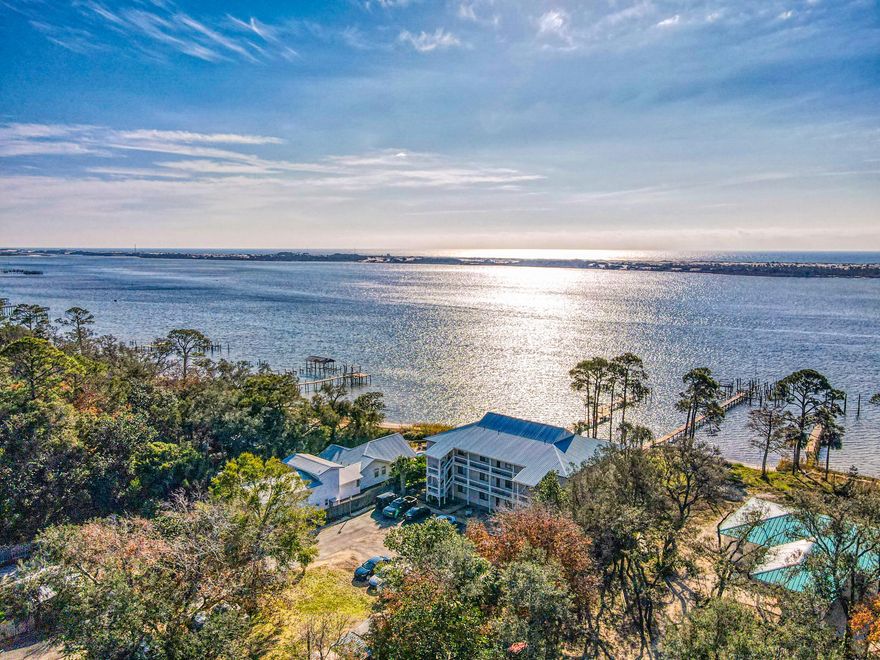 Enjoy the spectacular sunsets and views of the Santa Rosa Sound from your balcony and interior rooms from the third floor! This 3BR/2bath waterfront condo could be a permanent residence or purchased as an investment for long term rental. Balcony is tiled and is 16 X 25. Only nine units have been built on this valuable waterfront parcel of land. The Association maintains the docks. Each unit has a separate storage building outside.  There is a nice size laundry room in the unit and washer and dryer convey with sale. New AC was installed recently as well as stove and dishwasher. Some of the tile has been replaced with wood laminate flooring. Custom storm shutters (accordion style). Being sold ''As Is'' due to cosmetic work needing completion. With paint and carpet replacement in one of the guest bedrooms, this unit could be adorable!   