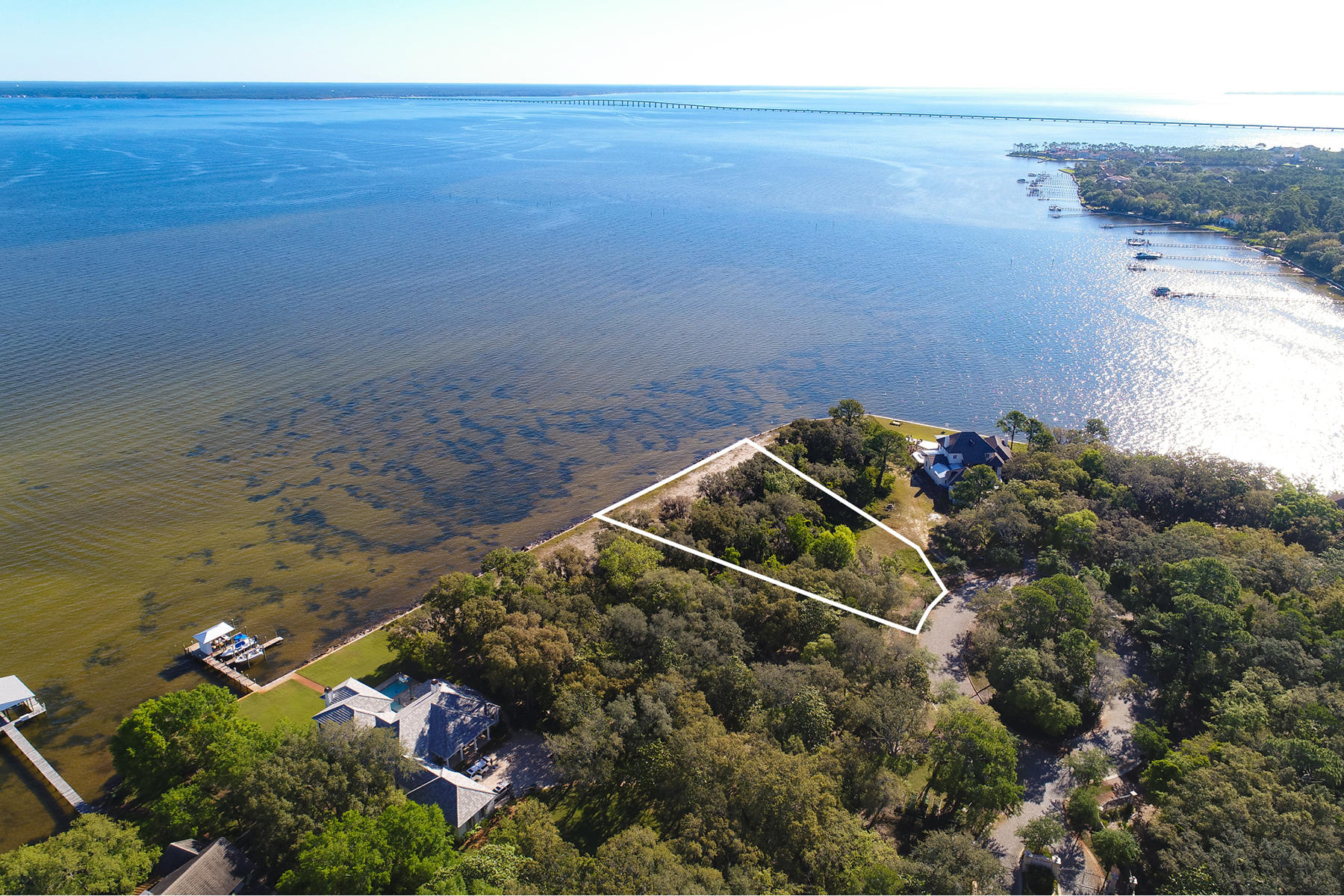 Double Lot Opportunity! The Estates at Indian Pointe gated community has been professionally designed for luxury, waterfront lifestyles that blend dazzling, unobstructed water views with abundant boating and water recreation. With 229 feet of Bay frontage this property is the best and the biggest in the area. More than 125 water surface square miles run some 27 miles long and up to six miles wide, affording boat enthusiasts opportunities for fishing, cruising, water skiing, kite boarding, parasailing and access to the Gulf of Mexico through East Pass or Santa Rosa Sound. Salt and freshwater fish reside here, and keep the binoculars handy for bald eagles, herons, jumping dolphin and wildlife indigenous