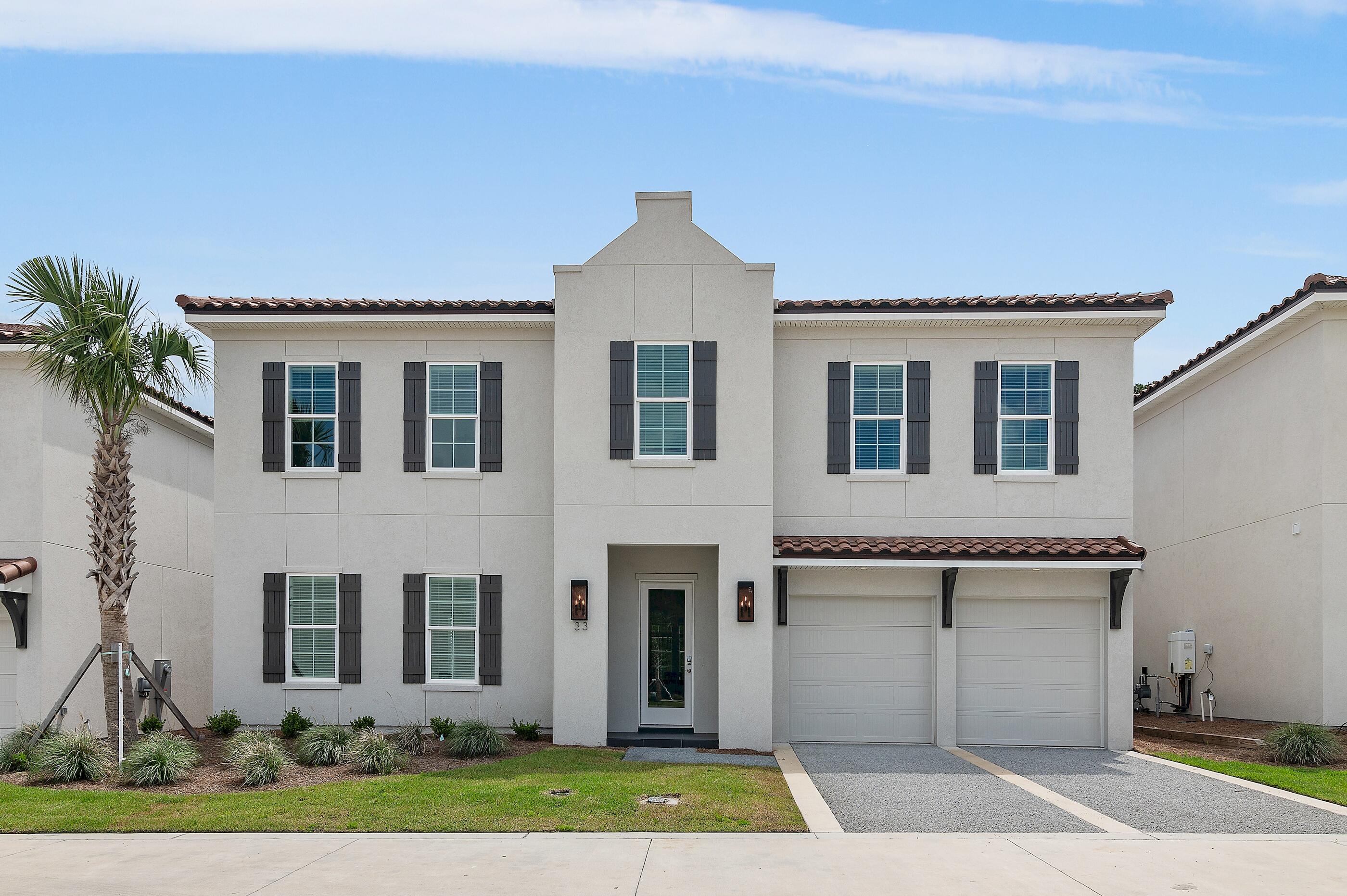Step into modern coastal elegance in this thoughtfully crafted residence, located in the exclusive gated community of Tops'l Beach and Racquet Resort. This newly constructed 4-bedroom, (plus bonus room), 4.5-bathroom home in Grand Villas, offers a harmonious blend of luxury and comfort across 3,454 square feet of thoughtfully designed living space. Enjoy the convenience of primary suites on both the first and second floors, each featuring spa-like bathrooms for ultimate relaxation. The open-concept kitchen is equipped with top-of-the-line stainless steel appliances, custom cabinetry, and a spacious island, making it perfect for entertaining guests. Step outside to a screened patio featuring a built-in grill, perfect for alfresco dining and enjoying the Florida breeze. A home theater that doubles as an additional bedroom and twin bunks in the upstairs sitting area provide ample space for family and guests. The upstairs sitting area also includes a wet bar. Dual laundry rooms on each floor add to the home's convenience. Situated within the exclusive Grand Villas at Tops'l Beach Club, residents have access to a private community pool, as well as, state-of-the-art fitness center, tennis courts, additional swimming pools, and deeded beach access. Tops'l offers a laid-back coastal vibe with proximity to beautiful beaches and a variety of recreational amenities. Experience the perfect blend of luxury, comfort, and convenience in this exceptional beach retreat. Whether you're seeking a primary residence, vacation home, or investment property, 33 Palm Ridge Road offers an unparalleled coastal living experience.