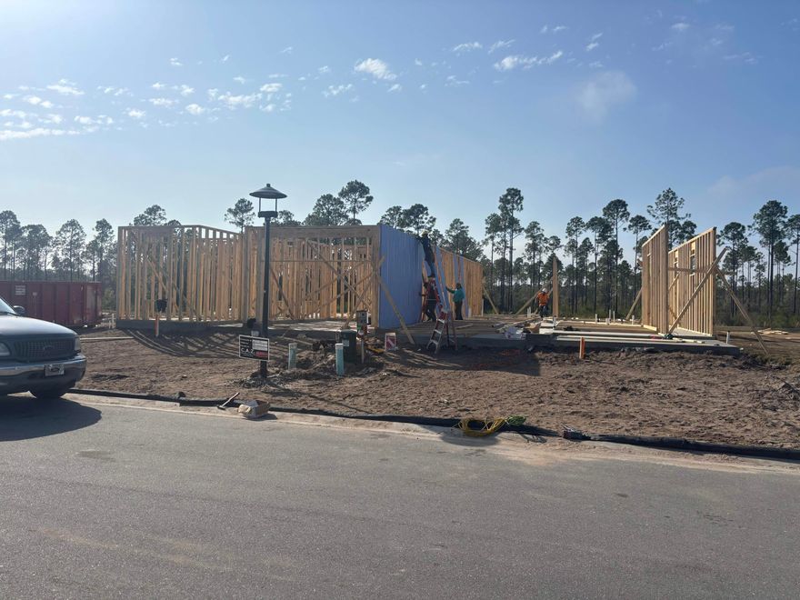 Construction has started and we're in framing! Enjoy serene views and effortless living in this Anfield paired patio villa by Fischer Homes, located in Long Leaf Park Villas at Watersound Origins. This thoughtfully designed single-level home offers 2 bedrooms and 2 full baths, positioned to capture peaceful wooded and dry pond views for added privacy.With 10-foot ceilings and a bright, open layout, the kitchen and family room connect seamlessly to the covered rear patio--creating a natural extension of the living space.The upgraded kitchen features quartz countertops, a farmhouse sink, enhanced cabinetry, a stainless canopy range hood, and a spacious walk-in pantry. With the powder room option located just off the Family Room, functionality is enhanced for guests and entertaining. Luxury vinyl flooring runs throughout the home, while both full baths showcase tile extended to the ceiling for a clean, elevated finish.

The Owner's Suite includes the Luxury Bath Suite and a generous walk-in closet, offering a comfortable retreat.

An installed Smart Home security package with remote access capabilities adds everyday convenience and peace of mind.

Enjoy low-maintenance living with HOA-covered lawn care and exterior upkeep, giving you more time to experience the exceptional amenities of Watersound Origins. Indulge in the Origins Golf Course, relax at the resort-style pool at Village Commons, enjoy sports courts and miles of trailsall within this vibrant, amenity-rich community.

This is your opportunity to embrace easy living in one of South Walton's most desirable neighborhoods. Schedule your tour today!