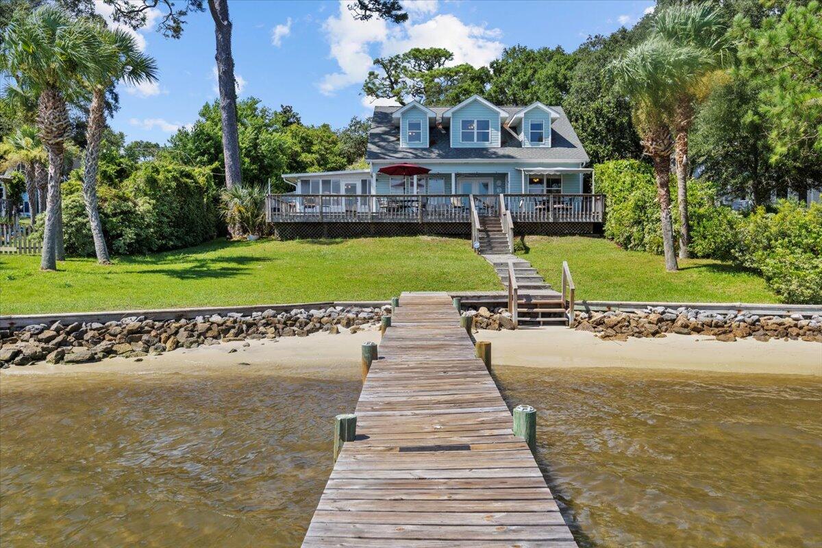 Nestled on the serene shores of Santa Rosa Sound, this exceptional waterfront property blends natural beauty with comfortable family living. Shaded by beautiful, mature trees, the home offers a peaceful sense of privacy while opening to stunning panoramic water views. A spacious deck spans the back of the house--perfect for outdoor dining, entertaining, or simply relaxing as the sun sets. The private boat dock invites endless days of fishing, cruising, or exploring the coastline. Inside, a large family room serves as the heart of the home, ideal for gatherings and making memories. The thoughtfully designed floor plan includes 5 bedrooms and 4 full baths, with a dedicated upstairs area where the kids can enjoy their own space. Completing the property is a charming 721 sq. ft. guest cottage. This is in addition to the 2466 main house square footage. Perfect for hosting friends and family, it also offers excellent potential for separate rental income. With its mix of main house comfort, outdoor living, and income opportunity, this property delivers the very best of waterfront living. Bring your boat, personal watercraft, or paddle boards and dive into the ultimate waterfront lifestyle. The main home's roof was replaced in 2014, the guest cottage's roof was replaced in 2018.
