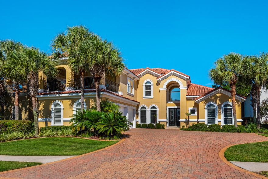 Custom-built Mediterranean villa with enclosed lanai and first-floor master suite in prestigious Destiny East. Beautiful landscaping and a pristine, cheery exterior make an eye-catching first impression. This home features the hallmarks of Mediterranean design: umber tones, elegant arches, wrought iron accents, and a barrel tile roof. Glass pocket doors that retract into the enclosed lanai seamlessly blend the interior with the exterior and optimize entertaining space. The spacious kitchen features a paneled refrigerator, double ovens, gas cooktop, and center island with sink for maximum functionality. The first-floor master suite offers access to the lanai, a large walk-in closet with built-in storage, and a luxury bath with spa tub and walk-in shower. The first floor office adjacent to a full bath could be used as a 5th bedroom. The second level boasts a large game/bunk room with a large covered porch for enjoying afternoon sunsets.This home also includes a tankless water heater and walk-in attic with energy efficient foam insulation. Sold partially furnished. There's room for a pool in backyard. Destiny East is an exclusive gated community with private beach access, community pool, tennis, and clubhouse. 