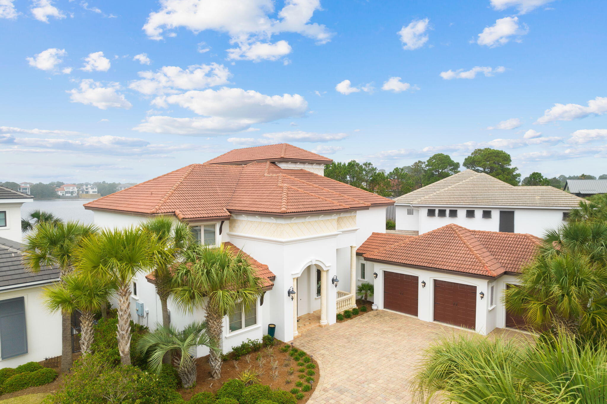 Effortless waterfront living and elegant Spanish design unite at this expansive Mediterranean inspired home located within the private, gated community of Destiny East. Spanning across nearly 4,900 square feet, this five bedroom, six bath home provides quality construction, an enviable location within the community, and traditionally upscale fixtures to create a uniquely desirable compound, footsteps from sugar sand beaches. Concrete block construction on the main level of the home is accented by oversized culinary and dining spaces, including a dedicated formal dining room, charming breakfast nook and eat-in bar island surrounding custom cabinetry, Thermador appliances and timeless tile work.