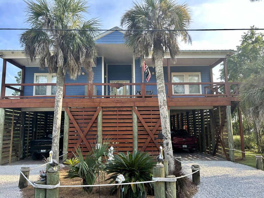 Welcome to your laid-back coastal lifestyle! Custom-built to be ''hurricane tough'' on 58 pilings, this bay front home is all about easy Florida living, great entertaining and amazing views.The spacious 2120 sq ft open floor plan features 3 bedrooms, 2 full bathrooms, vaulted tongue and grove ceilings and stunning water views from every single room. The kitchen boasts a massive granite island that flows perfectly into the lvign space. Under the house is an entertainer's dream, featuring a private guest suite with small kitchen and bathroom; a custom bar, plenty of room for outdoor games, and an outdoor bathroom and shower. Unwind by the waterfront fire pit or stroll down your private boardwalk to your covered boat dock. This property is completely turnkey and ready for you to enjoy!!