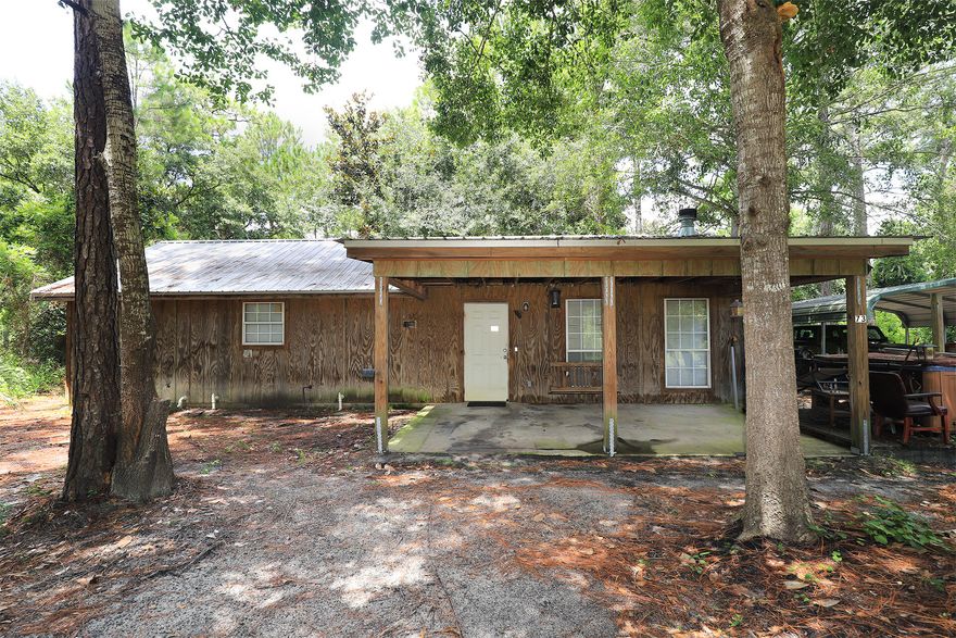 This solid  built and energy efficient home was built with  2x6 studs, shear walls and a tin roof... designed for low power bills,  low maintenance, and also easy functioning floor plan as a small house to move through. The home is  1 story  with  2 bedroom /1 bathroom open floor plan, wide hallways, spacious bedrooms and bathroom giving space to move around. Large living room with wood burning fireplace and tile floors. Bead board walls give the home the unique Florida cabin look.  The exterior of the home is pressure treated wood. Half acre lot with 2 driveways providing plenty of  space for multiple cars, boats, and  RV (with utility hookups on the lot). A car port is in one of the driveways. There are no neighbors on either side of this home which provides  privacy yet still in the heart of Santa Rosa Beach  within 10 min to beach, shopping, restaurants. see. 
There is additional land available, .50 acre parcel is  for sale as well see MLS #95328 