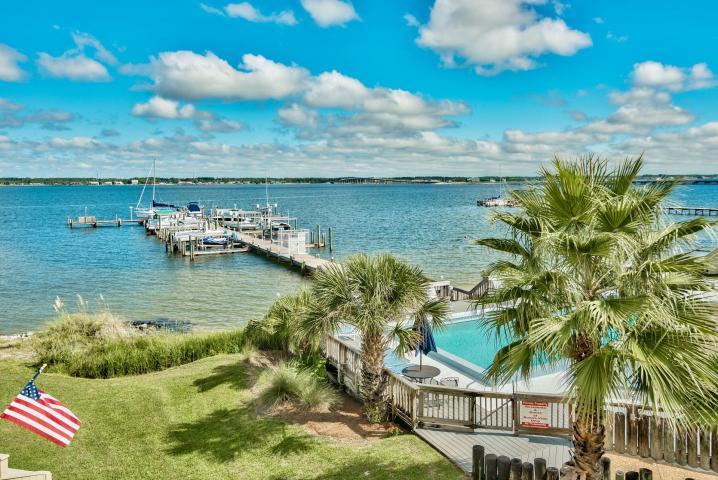Gorgeous Views of Sound with Deep Water Boat Slip and Boat lift! Living at its BEST! Beautiful view of the Sound and pool! Upgrades throughout this 2300 sq. ft. townhome w/4 bedrooms, 2.5 bath home; Two bonus rooms (1st floor and 3rd floor loft) make this a great buy for primary home or second home. Views of Intercoastal Waterway from living room, dining room, loft, bonus room and all bedrooms except one. Features: Tile/patagonian pecan floors, Murano Italy hand blown glass chandelier in foyer, Designer MacKenzie-Childs hand painted sink in bath with groen fixtures. Full Bath on second floor with laundry room, tub and shower. Large walk-in closet in the master suite w/balcony on 3rd floor offering privacy and full waterfront views, overlooking the pool.