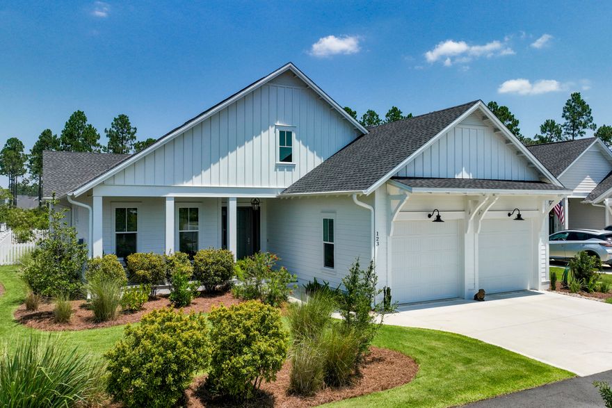 Located on a premium lot backing onto green space, this delightful Florida cottage boasts numerous upgrades. Ten-foot ceilings with crown molding set the tone for a quality home along with rich Medallion hardwood floors, upgraded appliances, and solid core doors. All on one level, this upscale home has four bedrooms and three-and-a-half baths, all generously sized and well-appointed. Park on the wide driveway that leads to the two-car garage. A glass entrance door adds natural light to the foyer, showcasing the rich hardwood flooring and crisp white decor. It opens into an L-shaped family room that provides a comfortable space for memorable family gatherings or entertaining friends. Between the sitting area and the open-concept kitchen, the formal dining area exudes modern elegance with a stylish chandelier. The chef's kitchen has bold black cabinets that contrast with sparkling quartz countertops. The island provides plenty of practical workspace for guests to gather and socialize over cocktails and canapes. Quality stainless steel appliances include a vented hood and space-saving microwave drawer while under-cabinet lighting adds a soft glow where you need it most. Head out onto the covered porch which extends over 30 feet in width and has a wall-mounted TV and privacy shades. It's a tranquil space for relaxing, dining or enjoying barbecues on the adjoining paver patio, recently added upgraded gutters, within the fully fenced yard with room for a pool. Watersound Origins has first-class amenities such as a community pool, pickleball, tennis, golf, exercise room, watersports on Lake Powell and access to the sugar-white sandy beach. Optional membership to the exclusive Beach Club includes the use of zero-entry pools, beach chair set-up and waterfront dining at this coastal haven.