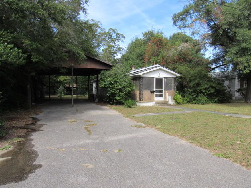Great opportunity to own a double lot in the heart of Crestview. Home sits on .48 of an acre with 2 bedrooms and 2 full baths. The house has a screened in front porch. Living room has newer flooring. The kitchen is a good size with a lot of cabinets and has a window looking out over the back yard. There is a separate and large laundry room at the back of the house that can also accommodate extra storage. The back yard has a chain link fence with a cement slab for a yard building or such. There is also a very large carport that can house two boats or RV's. The lot adjacent to it that is part of the property offers a lot of elbow room. Buyer to verify all pertinent information as to satisfy themselves. Property being sold 'as is'.