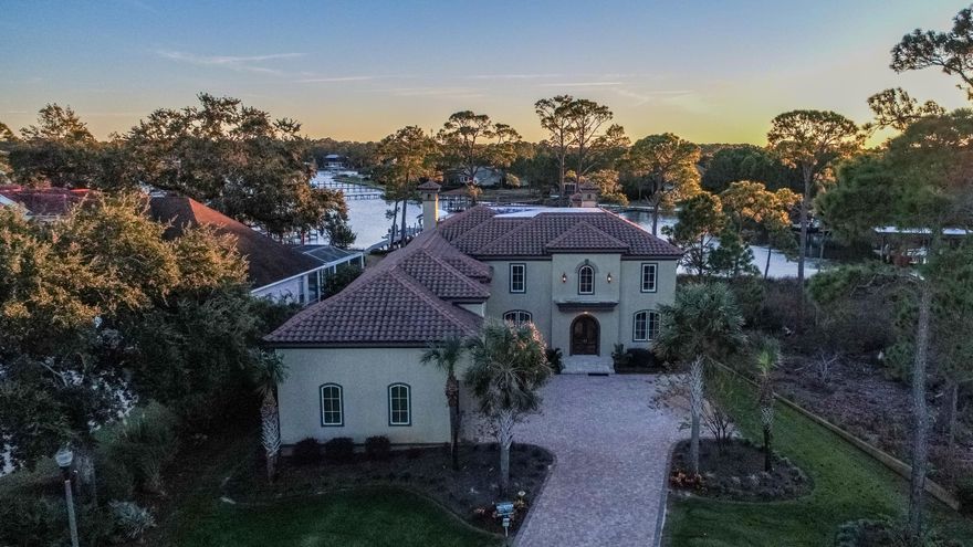 Stunning Bay front home with Deep Water access in the quiet, gated Grand Cove Community! Boaters Paradise, will accomodate a bay boat on lift and has a larger 40+ ft boat dock, 2 Jet Ski lifts, plus a huge deck on top with amazing views! Features include: Chefs kitchen with Sub Zero and Jen-Air appliances, butlers pantry and breakfast bar, custom cabinets, shelving and built ins throughout, 823 sq feet 3 car garage, Elevator, hardwood and travertine floors, 3 fireplaces, high-end crown molding throughout, large screened in patio with swimming pool, huge master suite with gigantic his and her closet. Home is currently set up as a 6 Bedroom house as the room behind the living area is being used as a guest bedroom with 3 twin beds, but would also make a great office!