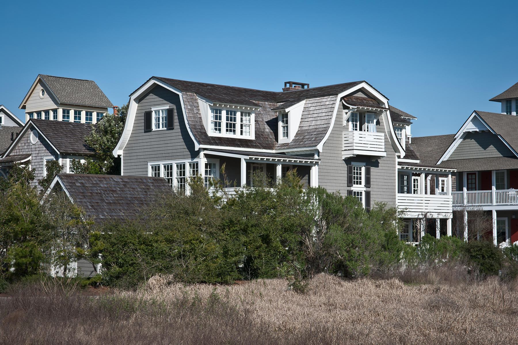 This second row home in WaterSound Beach, designed by revered Architect Bobby McAlpine, avails itself of sight lines to the Gulf, both over the beach boardwalk which it faces, as well as between the two currently vacant Gulf front lots between it and the mountainous dunes this gated community is known for. These sight lines are almost certain to be preserved even after build-out of the community completes. Traditional architectural elements such as the gambrel roof, characteristic of the Nantucket coastal style WaterSound is inspired by, combine with crisp, modern details to create a residences that is timeless yet mindful of modern living.