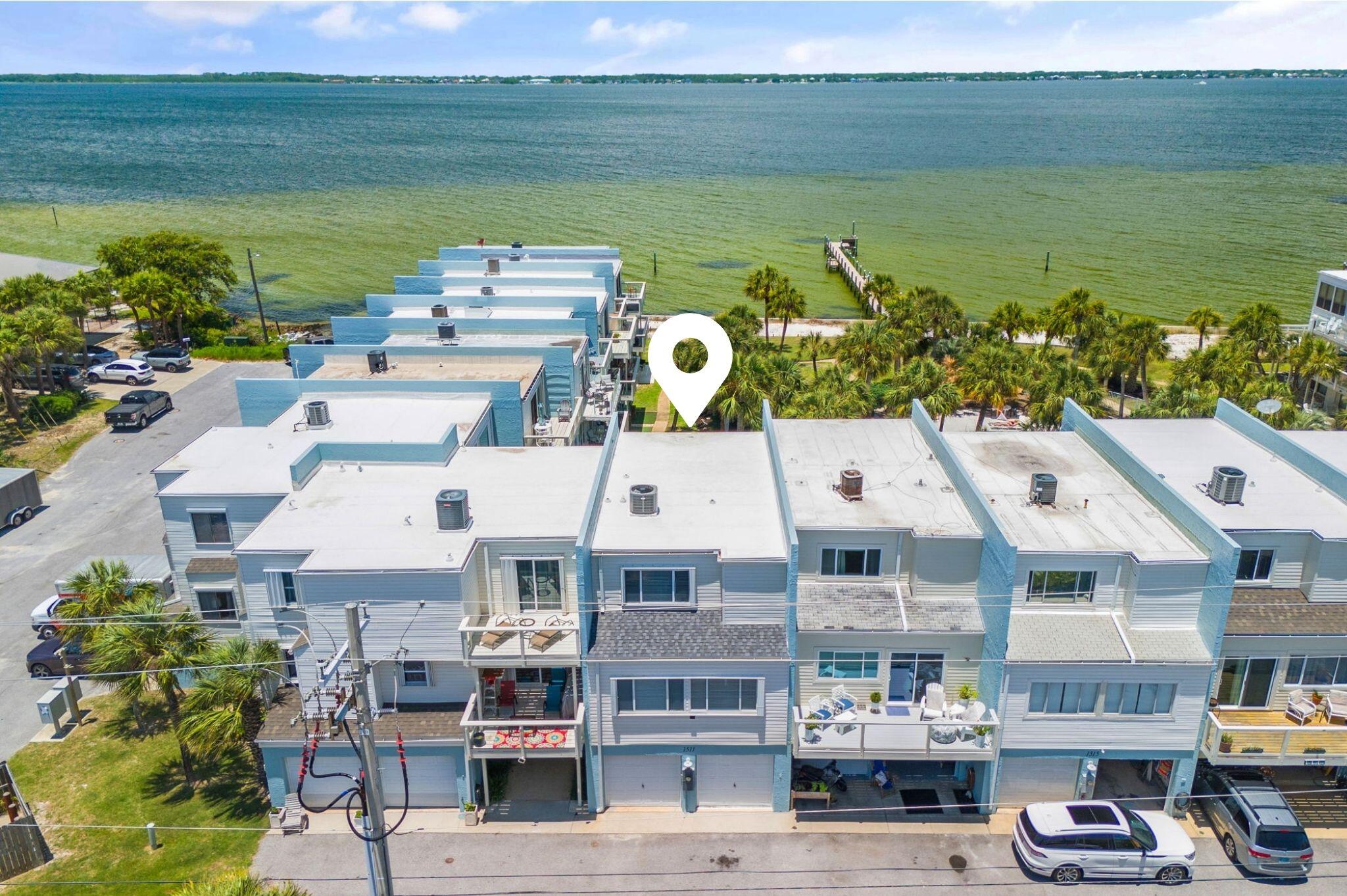 Prominently positioned to showcase the stunning views of the bay throughout the unit, this stunning coastal retreat spans three distinct levels totaling 1,900 square feet. Upon initial entry, you're welcomed into into a spacious mother- in-law suite, currently configured as an art-studio, featuring sweeping views of Pensacola Bay, custom storage with beverage fridge, and smooth shiplap accented walls. Upstairs, the main living and dining area offer stunning views of the surrounding topography and features a thoughtfully designed coastal color palette, tall ceilings, and beautiful tile flooring. A bayfront balcony beckons for outdoor gatherings, the perfect place to indulge in a morning cup of coffee, lunch or dinner, while taking in the ocean breezes and idyllic bay views. The fully renovated kitchen is equipped a luxury caf?? appliance suite, stunning quartz countertops coupled with a stunning coastal backsplash, warm wood tones and new fixtures. A guest suite, accessorized with two twin beds, desk and private-ensuite complete the 2nd level.
Ascending to the third level, the spacious, bay-facing primary suite is a true oasis, flooded with natural light and a private terrace expanding the full width of the unit, ideal for taking in the renowned hues of the Emerald Coast sunrise and sunsets. The spa-like ensuite features dual vanities with modern fixtures, white ship-lap walls, and a private water closet with bath. Just down the hall, the guest suite offers a queen size bed, views overlooking the surrounding greenery, and a private bath.
This rare, bay-front unit has been immaculately maintained and features tons of premium upgrades to include a newer HVAC (2020), Roof (2021), tankless water heater (2020), newly painted exterior, newly remodeled kitchen with all new appliances, newly painted interior, accent walls, cabinetry, and much more.
The low-density community of Bahia Paz townhomes is tucked away in the heart of Pensacola Beach and is located just a short 2-minute walk to the renowned Emerald Coast beaches. Guests and owners can enjoy stunning green spaces, a beautiful community pool and private bay-front dock, perfect for heading out on the water with a kayak or paddleboard for an afternoon adventure. Boaters will love the easy access to the Santa Rosa Sound, perfect for sunset cruises or fishing trips.
The culmination of luxury and exclusiveness creates a truly intimate setting while remaining geographically poised near all of the acclaimed dining and entertainment venues Pensacola Beach has to offer. This a true compelling opportunity for both full-time and second-home residents alike. Inquire today and start living the coastal lifestyle you deserve.