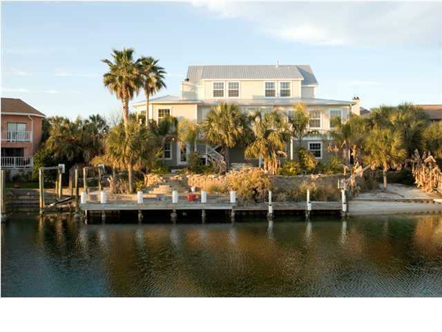 BANK OWNED Canal Front Beauty. EXTREMELY FLEXIBLE OWNER FINANCING AVAILABLE. This almost new 7BR/4.5BA canal front home's hardwood floors and light filled lead straight to the canal front with lush landscaping, a kidney shaped pool and dual boat slips. Clean lines, granite surfaces and soothing colors combine for a relaxing and tasteful residence on the water. Extras make this home an entertainer's paradise. A gourmet kitchen, a wine tasting/storage closet, a built-in cigar humidor, 2 fireplaces, a steam shower and an elevator keep guests coming back often. Wide spaces, ample outdoor places and music throughout make room for a variety of interests. A first floor lock-out with its own kitchen/living/sleeping offers privacy for guests or serves as party central for poolside