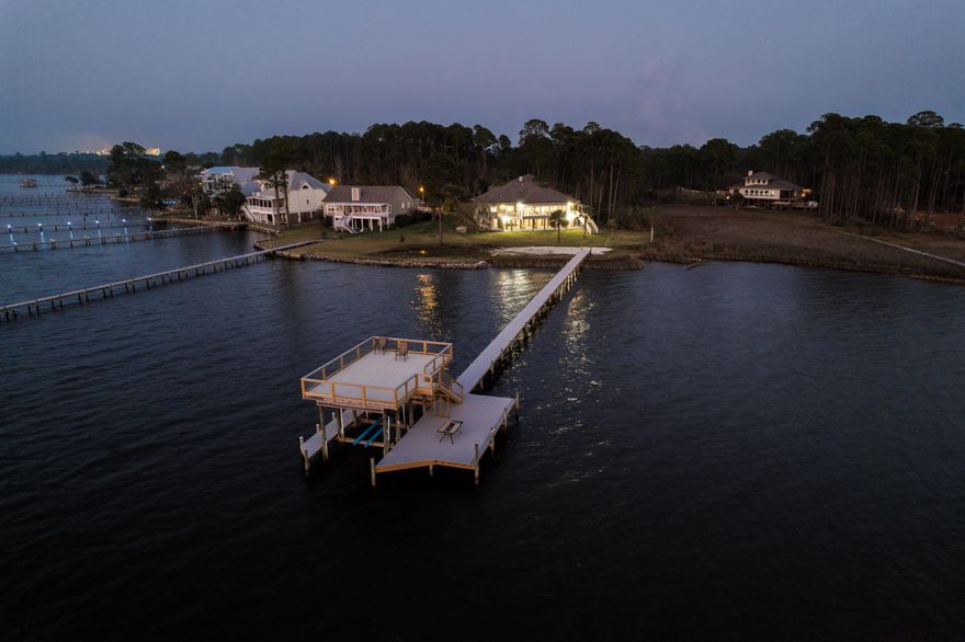 Conveniently located just minutes from I-10 and 20 minutes to downtown Pensacola, this 4-bedroom, 3-bath home boasts spectacular bay views. You'll enjoy a 3-car garage, a covered and enclosed lap pool with 180-degree views of the bay, and tons of surrounding space, perfect for entertaining family and friends. The kitchen comes equipped with ample cabinet storage, granite countertops, an island with a breakfast bar suitable for six people, a built-in wine rack, and stainless appliances. The primary suite is suitable for a king-sized bed, features water views as well as Florida Room access, and comes complete with an en-suite bathroom that boasts a walk-in closet, two granite-topped vanities, a jetted tub, and a walk-in steam shower. The kitchen, living room, and master suite all connect to