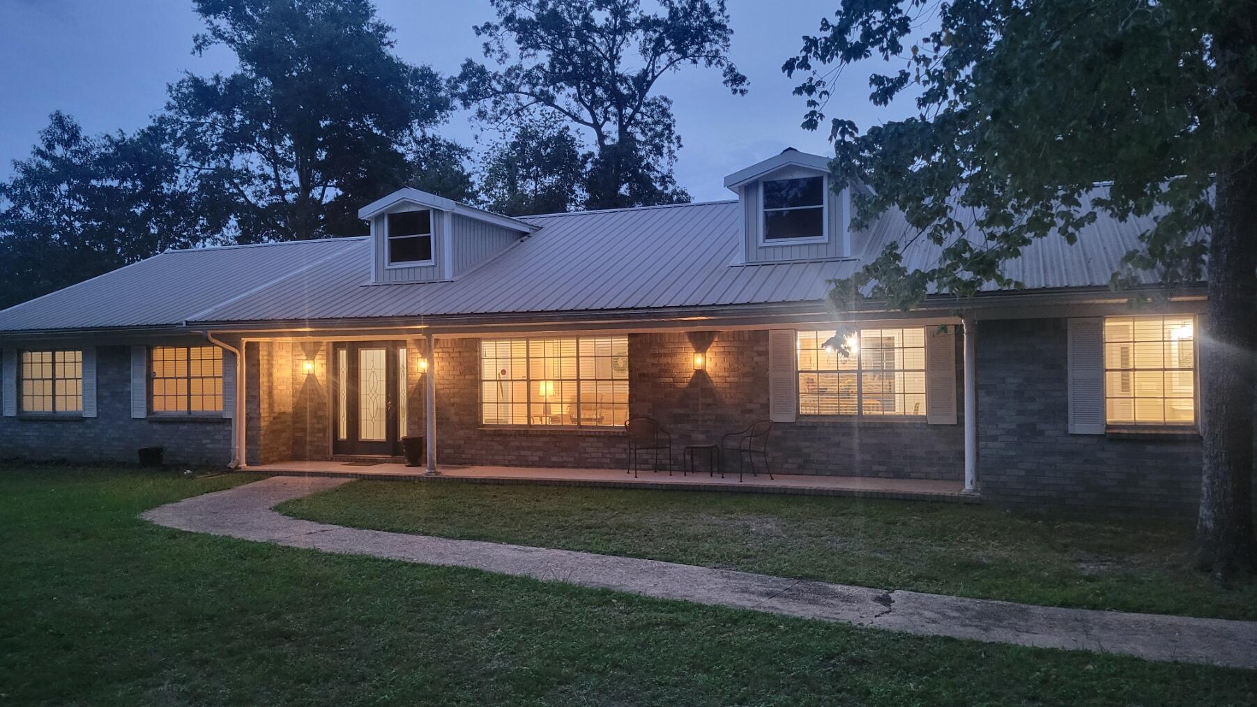 FULLY WARRANTED SOLAR PANELS (~$43K) PAID OFF AT CLOSING WITH FULL PRICE OFFER, RESULTING IN DECADES OF SAVINGS ON ELECTRICITY. This wonderful 2625 square foot home sits on a gorgeous half acre lot. The primary suite boasts an outstanding 500 sq. feet to escape in privacy, with a beautiful soaking tub, walk-in shower, two full-size closets, and French doors leading to the back porch! At the other end of the home, you'll find three more bedrooms, one including an en suite bathroom with a walk-in shower. The third full bathroom in the hallway ensures that you will never be fighting over the restroom. The beautiful dining and sitting room provide the feeling of separate spaces, while maintaining an open floor plan with the large cased opening to the spacious kitchen and living room, which are made cozy by a beautiful brick gas fireplace.
The two-car carport has plenty of enclosed storage space for bikes and outdoor equipment, as well as attic space for less commonly used items. The large shop in the backyard has ports for mowers and bikes, and being equipped with electricity, makes a wonderful space for handiwork. A separate fenced section in the backyard makes for a wonderful dog run, or with its large gate, would easily store a boat or other large toys.
Gillis Drive is a quiet street in a mature neighborhood, only 5 minutes from groceries or downtown. Don't miss your chance for incredible electric savings combined with a beautiful, one-of-a-kind home in Crestview!
Sellers will purchase a one year home warranty for property at closing.