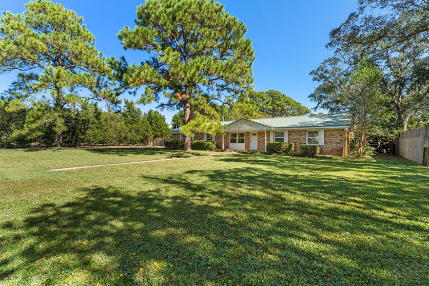 Move in ready home on a fantastic .69 acre lush green lot on a small lake in Destin! This home is an oasis in a town that can be so busy. From the minute you arrive home, you feel like you're on vacation! Enjoy your favorite drink from the screened in porch overlooking the lake.Freshly painted. Stunning LVP floors throughout the home. Large living room with a fireplace. Dining room & kitchen have French doors that open to the backyard and lake. Just imagine the dinner parties you could have! Updated kitchen with granite counters and stainless appliances. Master suite is on the lake side of the home & the 2 Bedrooms share the hall bathroom. The 3rd bathroom is in the garage so perfect to clean off after a busy day working or playing outside.Two year old metal roof! Oversized garage. No HOA!