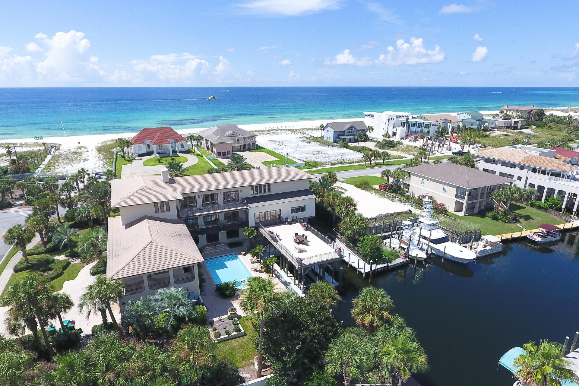 Masterfully built cast & pour concrete construction prominently situated on one of the largest residential home sites on Holiday isle with 90' of deepwater harbor frontage paired with expansive gulf views and exceptional proximity to the beach. This home has been recently updated with coastal contemporary decor as well as a floor plan modification to bring the total bedroom count to eleven in order to optimize short term rental income with projections exceeding $375,000 annually with current actual income exceeding $370,000 year to date for 2018. As of 2018's 4th quarter, there is already $258,000+ booked for 2019.