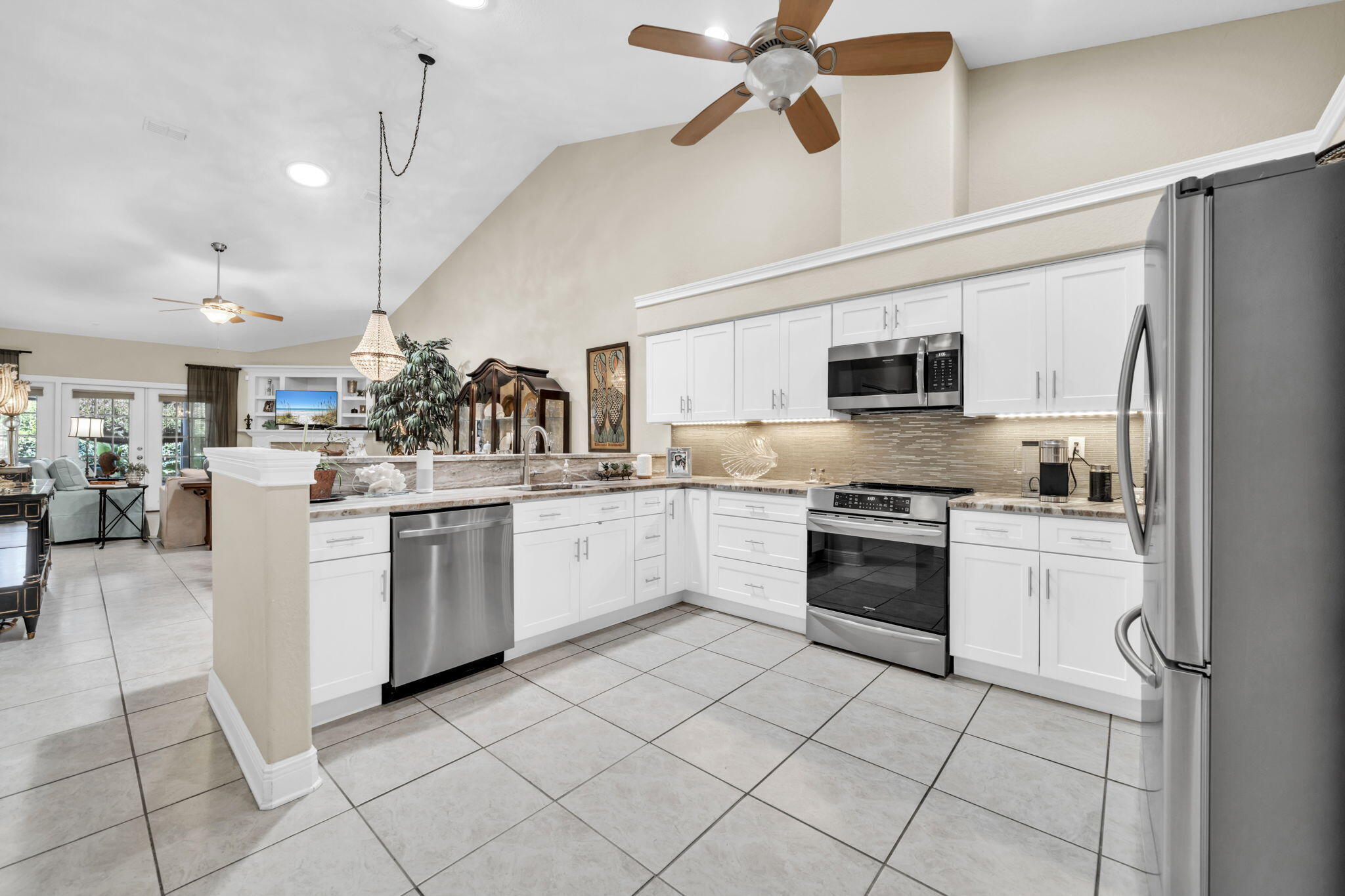 This beautifully updated home has been meticulously renovated with high-end finishes and thoughtful design throughout. The heart of the home--the kitchen--was taken down to the studs, reimagined with opened-up walls, and outfitted with custom, professionally designed cabinetry, sleek leathered granite countertops, a newer induction stove, and stainless steel appliances.Both bathrooms feature granite countertops, modern lighting, and stylish fixtures for a spa-like feel. Major systems have been upgraded, including a top-of-the-line Carrier HVAC unit with a coastal coating for durability, and a new roof and hot water heater (2023) for peace of mind.Enjoy year-round comfort on the screened back porch overlooking a lushly landscaped backyard--a perfect spot to relax or entertain. Several energy-saving upgrades were made to the home, including two solar tubes and blown-in insulation installed in 2023, and two attic exhaust fans. As a result, the highest electric bill in 2025 is just $150.