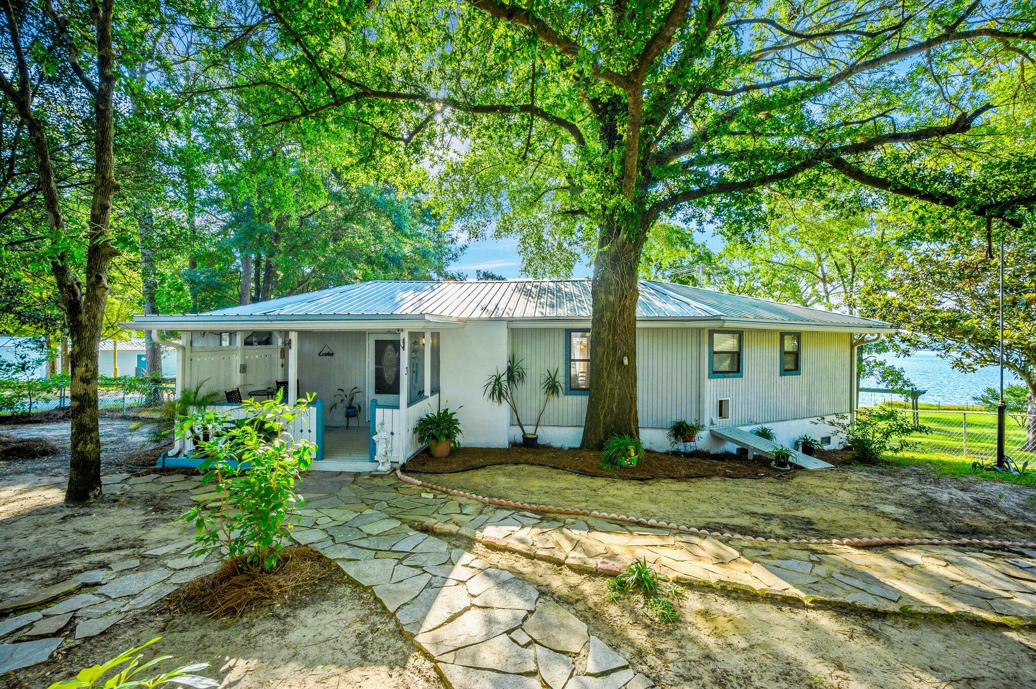 STILL SHOWING & TAKING BACKUP OFFERS!! This well maintained waterfront home is everything but ordinary with it's unique design!! It has 3 bedrooms & 2 bathrooms. The bonus room facing the lake has a full wall of windows to enjoy that gorgeous lake view. There is a 960 sq ft. workshop/garage with power & water. The enclosed & covered boat house is approximately 12 x 22 & is attached to a dock. Both are in need of some repairs. The metal roof is only 1 year old. Home comes with upgrades such as security cameras, TV antenna tower w/over 1000 channels, remote dog door, electric fireplace, & lakeside fire pit. It's away from the hustle & bustle but still a short 10 minute drive into town & under an hour to the white sandy beaches of South Walton. Open to all loan types.
