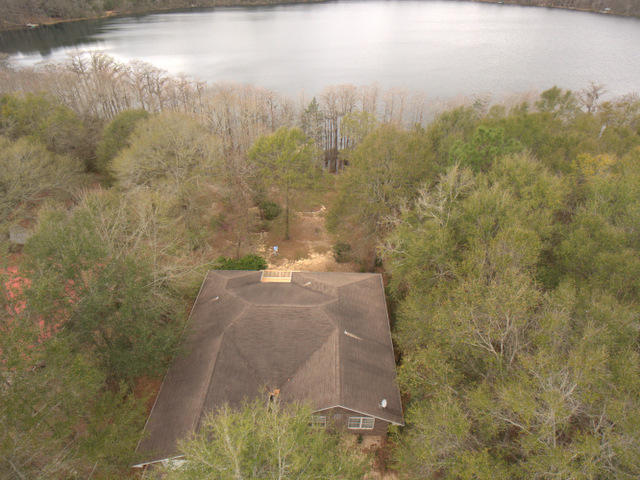Awesome Lake front living with black top road to the property. This is a great retreat for the person that wants a stunning lake out back, beautiful views, privacy on 1/2 acre, a quality home and lifestyle at a very affordable price . Inside you will find smooth flowing floor plan, a cool screened porch overlooking the lake, a sunny breakfast room, laminate wood floors, a sun room full of windows and lake views, 3 bedrooms in a split bedroom floor plan, a very large master bedroom with room for an office, walk-in closet, whirlpool tub, double vanities, raised ceilings throughout, gas fireplace, a kitchen with ample storage and amazing lake views from almost every room. Outside you will find a mature landscaped yard, cypress trees, private well, 1 year old Heat pump& a large deck to relax.