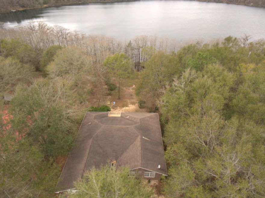 Awesome Lake front living with black top road to the property. This is a great retreat for the person that wants a stunning lake out back, beautiful views, privacy on 1/2 acre, a quality home and lifestyle at a very affordable price . Inside you will find smooth flowing floor plan, a cool screened porch overlooking the lake, a sunny breakfast room, laminate wood floors, a sun room full of windows and lake views, 3 bedrooms in a split bedroom floor plan, a very large master bedroom with room for an office, walk-in closet, whirlpool tub, double vanities, raised ceilings throughout, gas fireplace, a kitchen with ample storage and amazing lake views from almost every room. Outside you will find a mature landscaped yard, cypress trees, private well, 1 year old Heat pump& a large deck to relax.