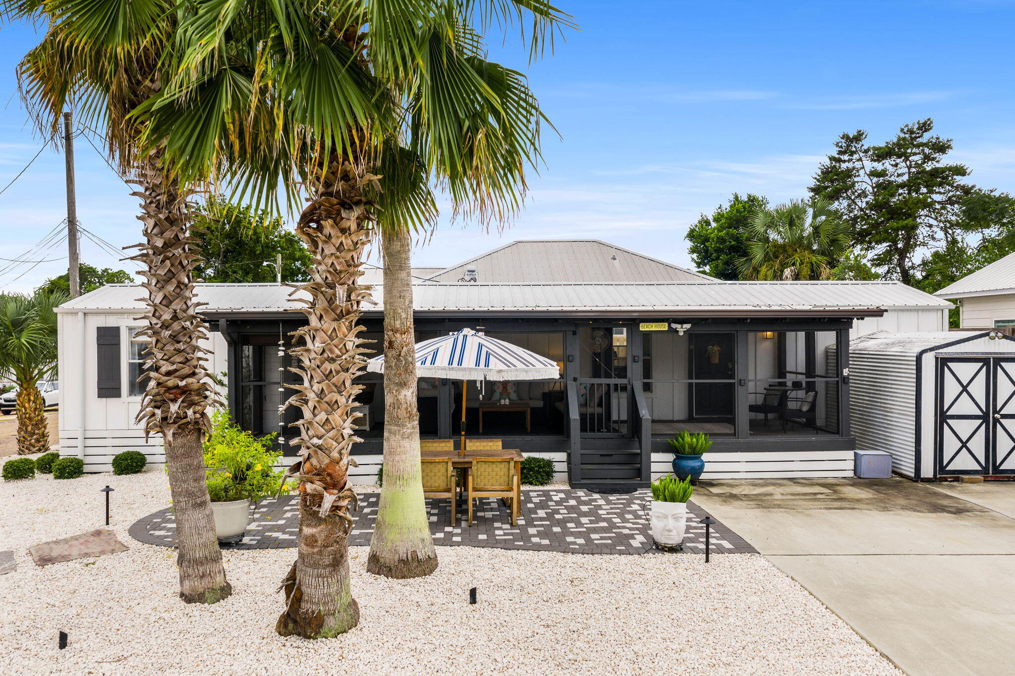 Looking for the perfect beach escape or a rental-ready second home? This sweet 2 bed/1.5 bath home on the west end of Panama City Beach is just what you've been searching for! Nestled in the laid-back community of Laguna Beach, this property oozes vintage beach vibes while offering modern updates and convenience -- and best of all, no HOA restrictions!Just a straight shot to the beach, this cozy home is fully furnished so you can start enjoying or from day one.Highlights include: Open living area with a split bedroom floor plan Oversized screened-in front porch with bistro lighting - perfect for morning coffee or evening chats Outdoor shower for rinsing sandy toes Xeriscaped, low-maintenance yard - more fun, less yard work Storage shed for your toys RV hookup - 30 Amp Zip around on your golf cart to The Carousel, Thomas Donuts, or cruise to Pier Park in minutes - everything you love about the beach life is right at your fingertips. 2022 gas powered golf cart/LSV is available for sale separately.
Whether you're looking for a weekend retreat, winter escape, downsizing to a more simple full-time residence, or a vacation rental, this sweet spot in Laguna Beach delivers.
Additional convenience features include irrigation/drip lines for potted plants, hardwired professionally designed landscape lighting, smart locks and thermostat, and smaller shed in rear for additional storage.