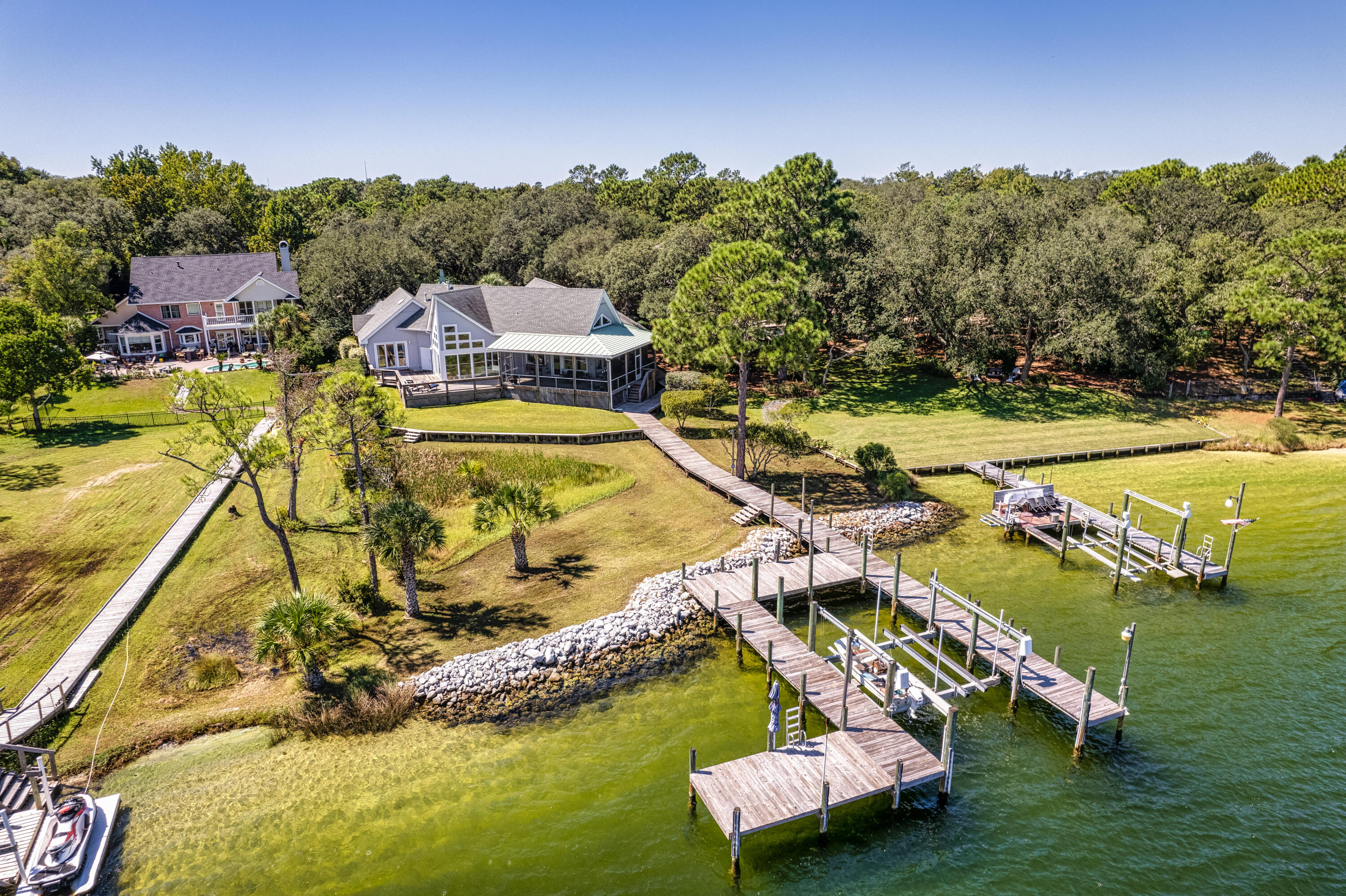 With 0.82 acres on this deep water property, you'll enjoy the live oak and palm tree lined drive up to this incredibly picturesque and stately home. Your family and guests will pull into a beautiful porte cochere with a yacht club/low country feel featuring a covered dock walkway across a large koi pond to the front door. Inside opens up to a large, cathedral great room looking out to an incredible and pristine view. This home has a split floor plan with a 1st floor, secluded master suite and office. It also features an incredible guest suite and loft above the garage along with another office area and even a large bait and tackle fishing room! The home has had many recent updates including roof and impact windows. The waterfront here is clear, clean, deep and well protected from storms!