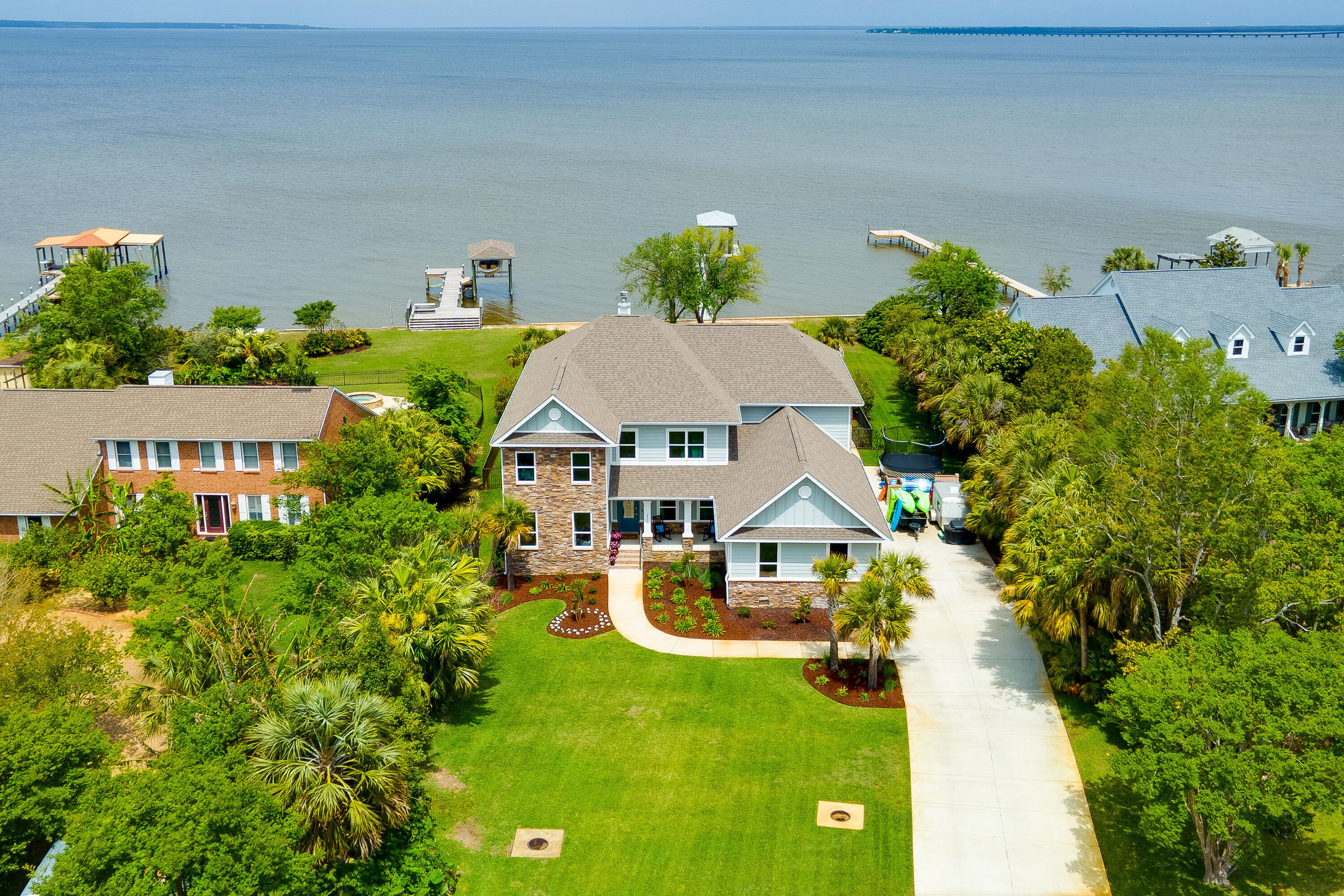 Upscale craftsman style home on Escambia Bay in the Whisper Bay Community. Enjoy stunning sunsets from your backyard oasis that includes a custom pool, built in fire pit, flow-through pier and boat slip. This home truly has it all: luxury finishes, bay view, entertainment space, 3 car garage, the list goes on. Relax in the huge family room that has stunning views of the bay, a fireplace that is surrounded with built in shelving and soaring ceilings. The lovely kitchen has a large island for food prep, pantry, gas cooktop and built in oven. The master retreat is located on the main floor, features a view of the bay and walks out onto a covered porch. The master bathroom has a soaker tub, walk in shower and dual sinks. There is a huge bonus space that can be used anyway you wish!