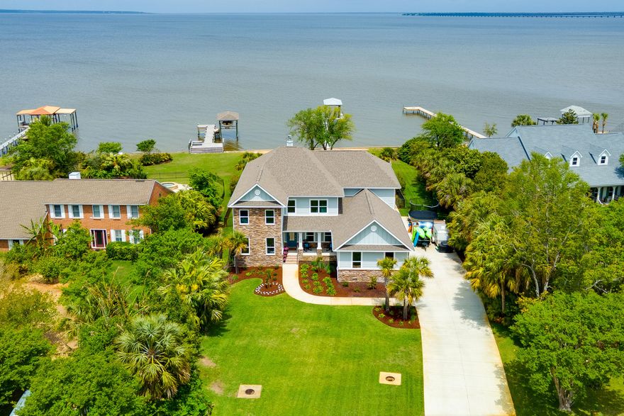 Upscale craftsman style home on Escambia Bay in the Whisper Bay Community. Enjoy stunning sunsets from your backyard oasis that includes a custom pool, built in fire pit, flow-through pier and boat slip. This home truly has it all: luxury finishes, bay view, entertainment space, 3 car garage, the list goes on. Relax in the huge family room that has stunning views of the bay, a fireplace that is surrounded with built in shelving and soaring ceilings. The lovely kitchen has a large island for food prep, pantry, gas cooktop and built in oven. The master retreat is located on the main floor, features a view of the bay and walks out onto a covered porch. The master bathroom has a soaker tub, walk in shower and dual sinks. There is a huge bonus space that can be used anyway you wish!