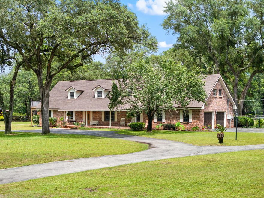 This unique property is in the heart of town but feels like you are out in your own oasis! Once inside this beautiful 2 story brick home with a circular drive you will find travertine floors, an updated kitchen with stainless steel appliances, a separate dining room and a wood burning fireplace in the living room. There are 3 bedrooms and 2 full baths downstairs. As you begin upstairs, you have a private bedroom suite to the right with a full bath and outside deck access. Across the hall is the main bedroom suite complete with a large bathroom, double vanities, large walk-in shower, and a jetted tub that looks over your private acreage. Off the rear of the main bedroom is a walk-in closet with enough space for storage, an office or a personal gym. The property has a tennis court, in ground Gunite Pool, sauna, and a separate guest house that has a full bath and kitchen (use this as a mother-in-law suite, studio or to generate some income as an Airbnb with its separate gate entrance for access). The back yard is fenced with an 1,856-sf steel framed barn and a separate Run-In. There is also a well Pump for lawn Irrigation. The main house, irrigation wellhouse and pool/guest house all re-roofed in 2021.  A new septic tank and fill lines were replaced for the main house June 2025. New tankless hot water heater for main house 2023, Main house had both HVAC's replaced in 2021 (2nd level) and 2024(main level). Pool house HVAC replaced in 2025. Everything has been updated, and this gorgeous home is ready for you to move in!  