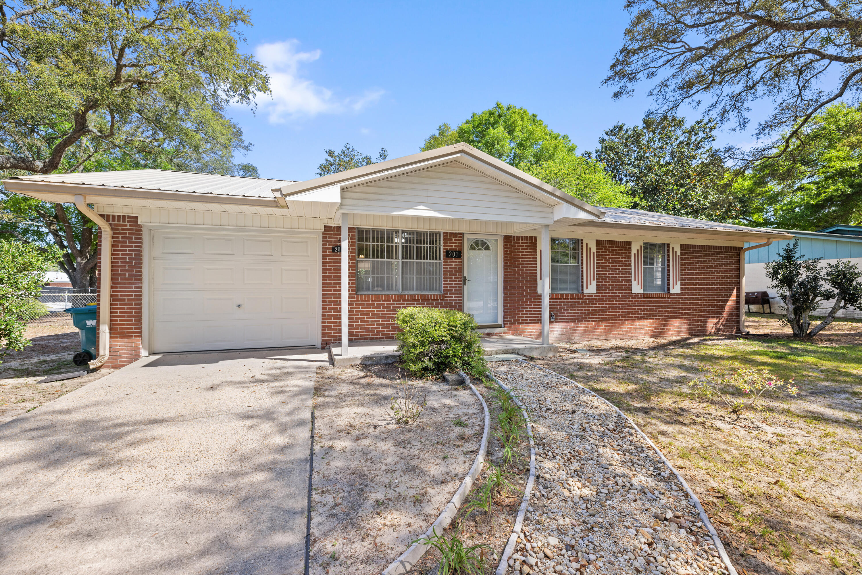 QUICK CLOSING AVAILABLE! One buyer's missed opp can be another buyer's golden opp.This property is an exceptional opportunity both in affordability and location for buyers seeking a well-maintained home. Situated in a central Niceville neighborhood and within walking distance of Lions Park, this residence offers a large corner lot enclosed by a rear chain-link fence. Large enough to store a boat, jet skis, and more. The lot will also support adding a future pool, a child's fort, or a playhouse. Oh, but wait, you say you have dogs...big dogs, multiple dogs, oh yes! Just let them run from corner to corner - they will sleep good when the day is done! The all-brick home features a one-car garage complemented by a detached one-car covered carport. Click ''Read More'' for more detail Despite the specified square footage, the house feels spacious due to its efficient layout. It boasts solid surface flooring throughout, including newer LVP flooring. The interior was freshly painted, and new interior doors were accomplished in March, 2025. The kitchen includes convenient features such as a glass top stove, side by side fridge with external water/ice options, a double stainless steel sink with a goose neck faucet, a lazy Susan cabinet, and a cookie sheet storage cabinet. The sliding glass door that leads from the dining area opens onto a covered 16 x 23 wood deck, perfect for serving outdoor dinner parties and more. The deck also has built-in wood bench seating to assist in the dinner parties. The HVAC system was installed in 2018 and is under an annual maintenance contract. Additional features include a newer Rheem gas water heater, a newer wind-rated garage door and auto opener, and two 220-volt 30-amp outlets in the garage. If you by chance have a large air compressor or you desire an electric whole house generator, that connection would work perfectly for that scenario. There is even a connection available in the garage area for powering an RV. The metal roof was installed in 2012. The expansive backyard offers ample space for gardening, and an 8 x 8 garden shed equipped with power, just not connected, to store those gardening tools. The property features blueberry bushes, gardenias, azaleas, mature shade trees and more. The seller is providing a one-year home warranty at closing, ensuring peace of mind for the new owner.