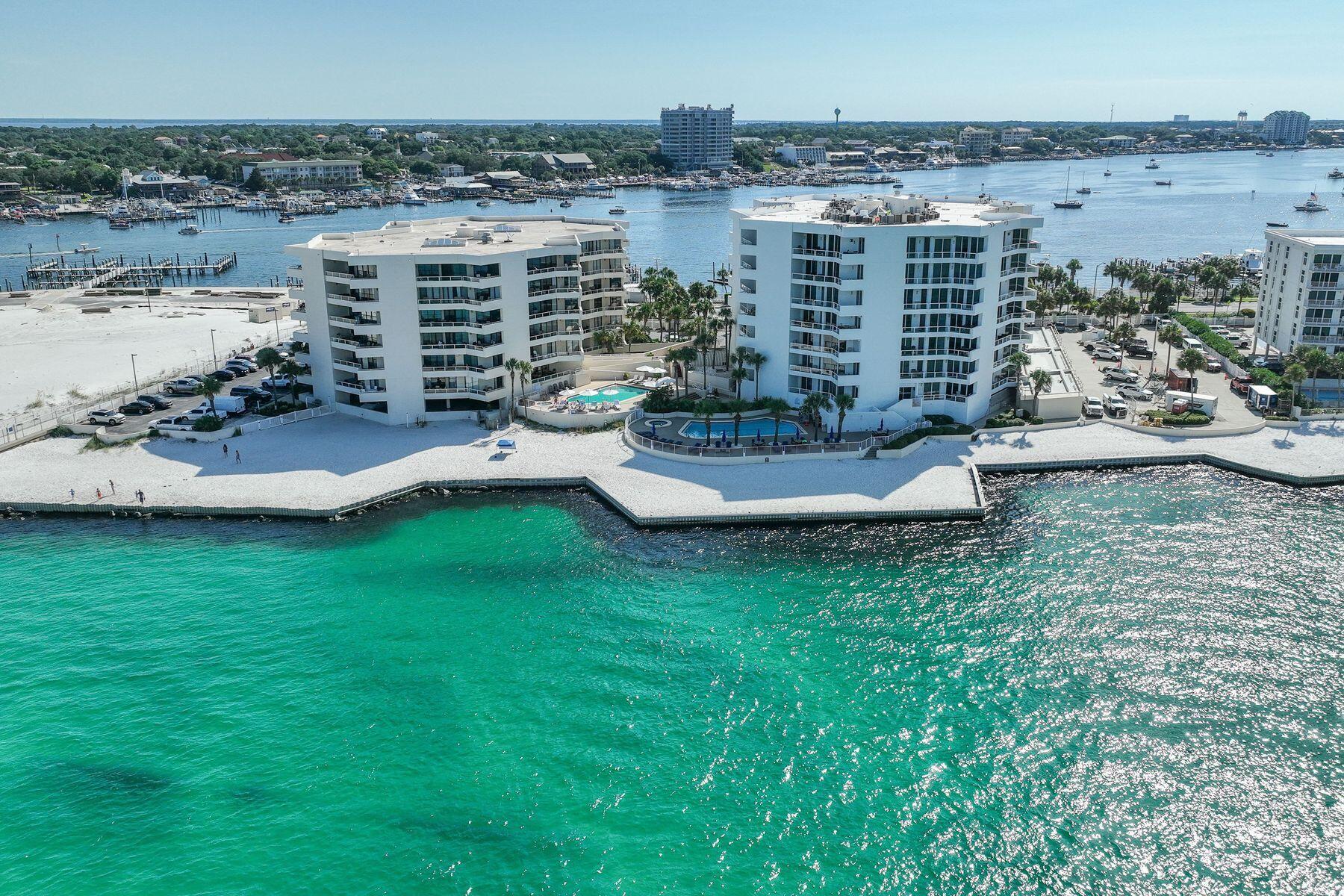 Two Master Suites. Beach or boater's delight. Gulf, East Pass and harbor views. Fireworks, air shows and incredible night light views from an expansive balcony. Perched on the sixth floor at the very tip of Holiday Isle, this gracious residence offers panoramic views that sweep from the Destin Harbor to the sparkling gulf waters of the East Pass. Walls of floor-to-ceiling glass and a generous balcony that spans the full width of the unit invite both sunlight and sea breezes into nearly every corner, creating a serene waterfront sanctuary. The spacious layout unfolds with ease, offering a large living and dining area that is seamlessly connected to a well-appointed kitchen, complete with granite countertops, stainless steel appliances, a generous bar, and a dedicated wine bar, all designed for effortless entertaining. Two private master suites, each with its own ensuite bath, provide luxurious accommodations for owners and guests alike, while a third bedroom and full bath offer additional flexibility. Resort-style amenities elevate everyday living, featuring an exclusive owners-only seasonally heated pool, hot tub, fitness center with sauna, a club room for events, as well as a private stretch of white-sand beach. A covered garage space right by the elevator entrance and dedicated storage room add convenience. A private marina just across the street occasionally offers deep-water boat slips for sale, for boaters who want to enjoy Destin's famed waterways. No boat, no worries, as you can call the boat taxi to pick you up at the East Pass Marina dock for quick trip across the water to award winning, boat-to-table seafood restaurants and night life on the harbor. East Pass Towers II is a secure, gated building renowned for its quiet, residential atmosphere with a 3-month minimum rental period. Featuring thoughtful updates, the condo association has proactively nearly completed all needed maintenance and improvements and all assessments have been paid by the seller. From fireworks and air shows on summer nights to tranquil mornings watching boats or dolphins glide by, this is waterfront living at its finest. Destin Executive Airport is just 2.3 miles away for all the pilots wanting to escape the beach or if you prefer charter services. Next to East Pass Towers and nearing completion of improvements is Norriego Point Beach Access and Park where, according to the City of Destin website, will include ADA accessible restrooms, showers, drinking fountains, environmental educational signage, bike racks, boardwalk, dune crossovers, and vehicle parking.