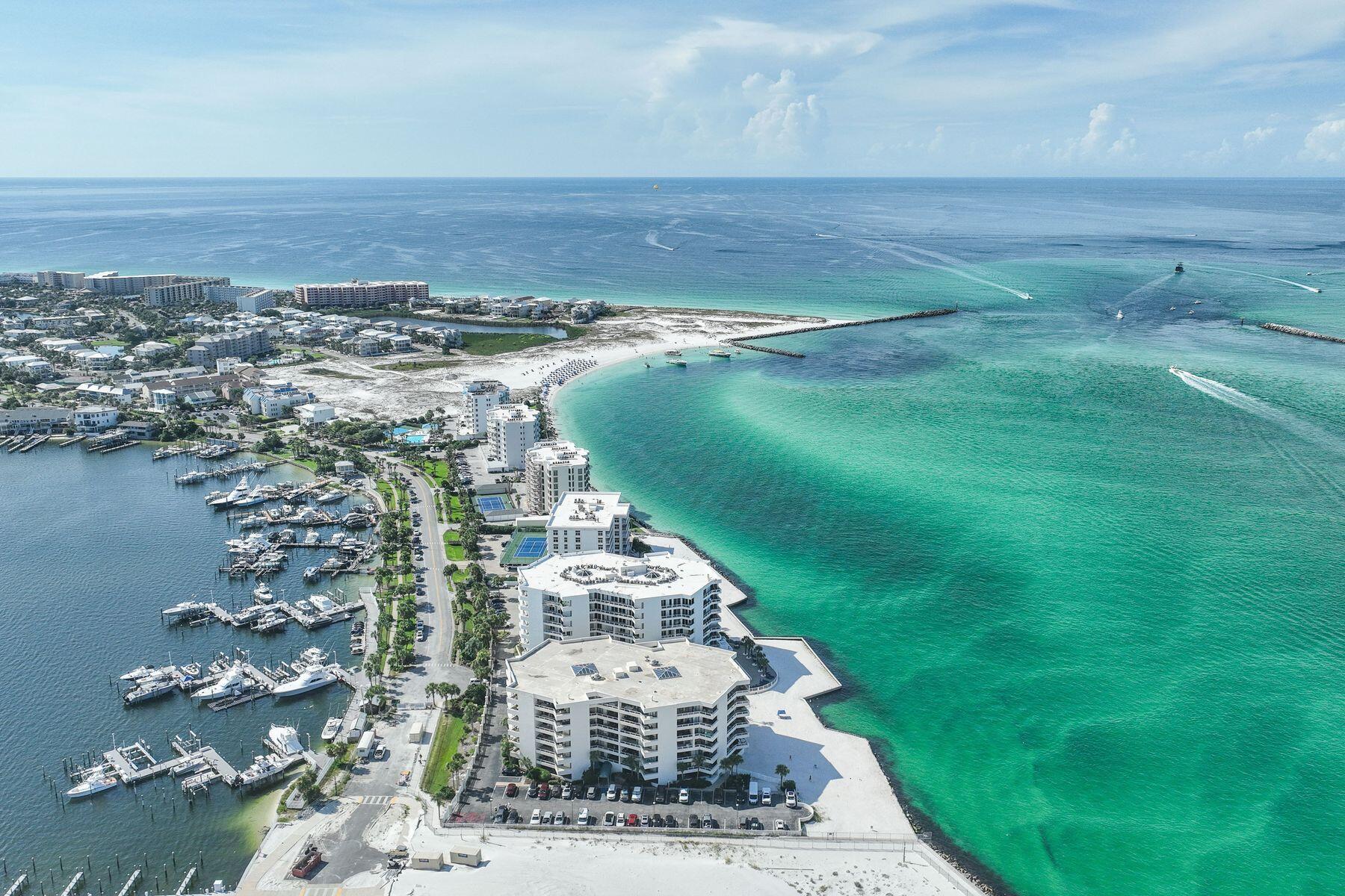Perched on the sixth floor at the very tip of Holiday Isle, this gracious residence offers panoramic views that sweep from the Destin Harbor to the sparkling gulf waters of the East Pass. Walls of floor-to-ceiling glass and a generous balcony that spans the full width of the unit invite both sunlight and sea breezes into nearly every corner, creating a serene waterfront sanctuary. The spacious layout unfolds with ease, offering a large living and dining area that is seamlessly connected to a well-appointed kitchen, complete with granite countertops, stainless steel appliances, a generous bar, and a dedicated wine bar, all designed for effortless entertaining. Two private master suites, each with its own ensuite bath, provide luxurious accommodations for owners and guests alike, while a third bedroom and full bath offer additional flexibility. Resort-style amenities elevate everyday living, featuring an exclusive owners-only seasonally heated pool, hot tub, fitness center with sauna, a club room for events, as well as a private stretch of white-sand beach. A covered garage space and dedicated storage room add convenience, while a private marina just across the street occasionally offers deep-water boat slips for sale, for boaters who want to enjoy Destin's famed waterways. East Pass Towers II is a secure, gated building renowned for its quiet, residential atmosphere with no short-term rentals allowed, featuring thoughtful updates that have already been paid for by the seller. From fireworks views on summer nights to tranquil mornings watching boats glide by, this is waterfront living at its most effortless.
