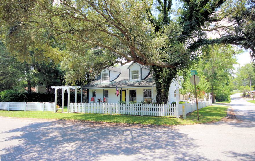 Back on the Market!! Consider the life altering possibilities in this rare jewel situated on a quiet corner lot with its southern flare. It features 4 bedrooms, 2.5 bath home with a 1 bedroom, 1 bath apartment above a garage perfect for parents, a grown child or a rental. As you arrive at the property, you are greeted by a white picket fence with a front covered porch with rockers just waiting for and wood floors throughout for easy care that perfect glass of ice tea and your favorite novel. This home is large enough that it can accommodate a large number of persons or those frequent guests to entertain. As you enter the front door you are received by a living room that is open with large windows to the floor that illuminates your home, fireplace mantle to display some of your treasures.