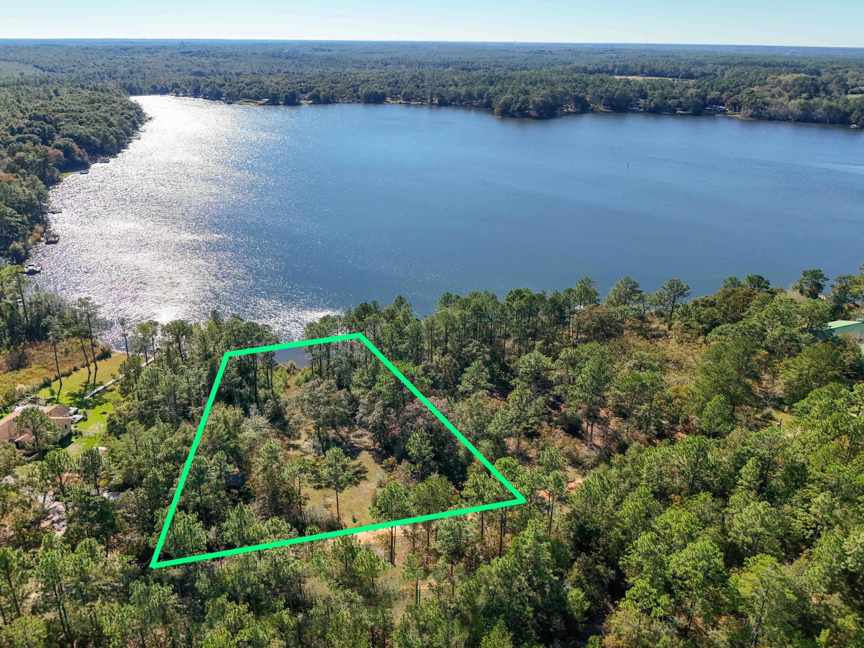 Dreaming of a peaceful lakeside retreat? This 1.5-acre lakefront property on picturesque Spring Lake is your perfect escape. With 217 ft of unspoiled waterfront on this 150-acre lake, the site is partially cleared, allowing for stunning water/sunset views, while the wooded perimeter ensures privacy and a natural backdrop. The property features a charming small cabin, ideal for weekend getaways or as a comfortable base while building your dream home. Located in a small neighborhood with basic restrictions designed to protect your investment, you'll enjoy the peace of knowing this is a community of owners; no short-term rentals here, just friendly neighbors who share your love for the lake. Conveniently located only 5-10 min to downtown DeFuniak Springs and 30-45 min to the sandy beaches. In addition to the dock onsite, there is a community dock, boat launch and pavilion for large gatherings on the 2+ acre community property. Don't let this rare offering slip by! 