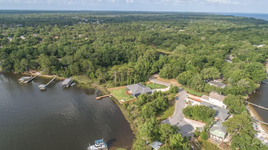 Craftsman waterfront home in Robledal Estates. 5 rooms!If you desire 100' on the Bay with your own private dock, then look no further! This home features white quartz in the kitchen and in all three bathrooms, with crisp-white cabinetry. Upgrades throughout with wood look tiles, and barn wood on some accent walls. Three of the rooms plus the office all have water views. Tall ceilings featuring crown molding, and extra cabinets in the laundry room. The room connects with a pocket door to the master closet also. The layout is designed for function and never ending views! Beach sand has been brought in between the backyard palms, and the landscape features Zoysia grass and an oversized deck. The homes elevation is high enough for the flood insurance costs of $829 per year currently. Must se