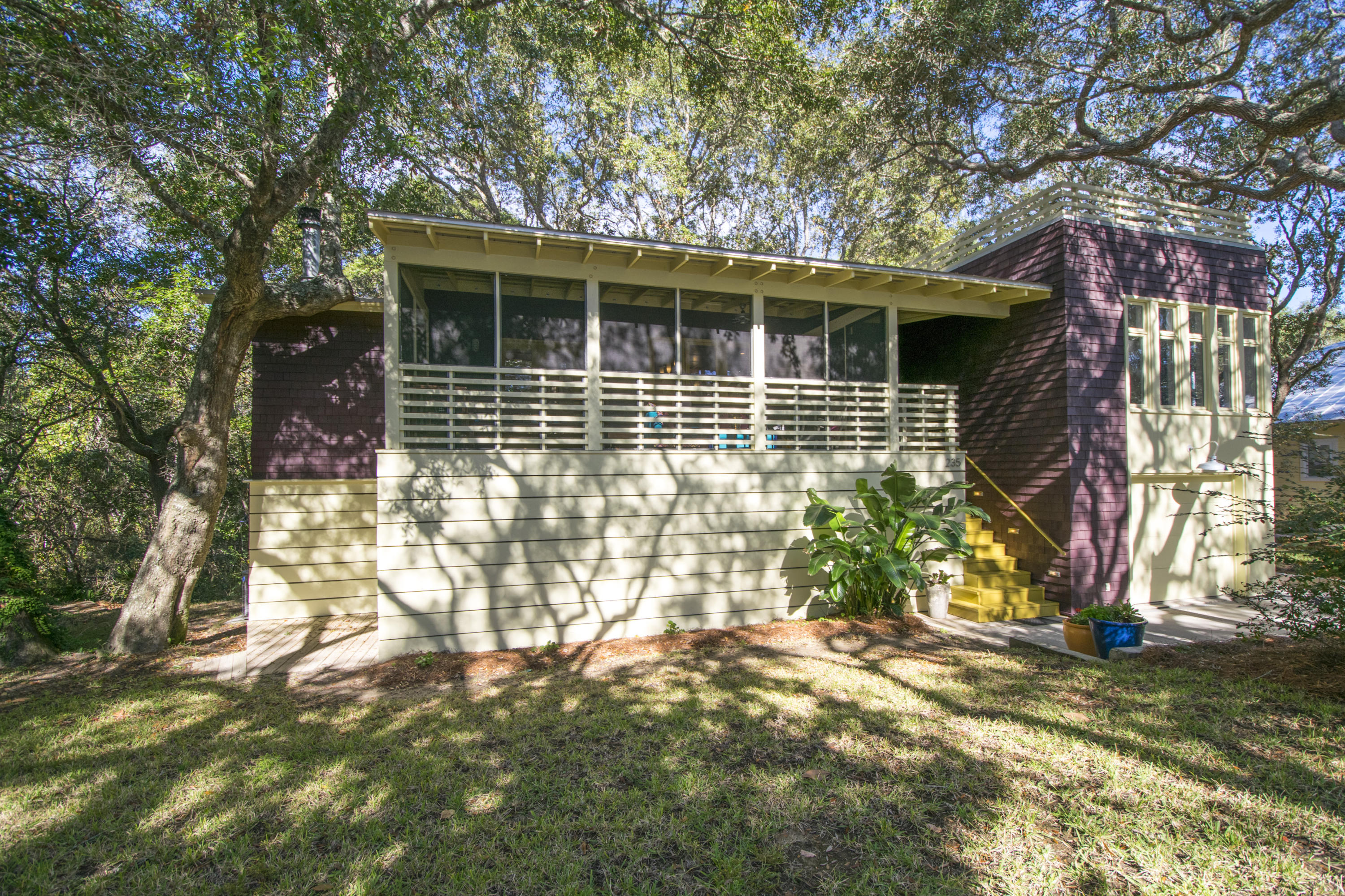 Nestled among majestic old oak trees in one of the best, real neighborhoods along 30a is where you will discover this gem of a home. Tastefully re-designed by noted local architect/owner Carey McWhorter, this home was featured, and selected as cover photo in the national magazine, Renovation Style, in the summer of 2004. Enter from the second story screened porch into an open living/dining/kitchen area that is graced with natural light and the beauty of nature from every window. Warm, polished maple hardwood floors and ceilings soothe the senses and create a decidedly modern feel to the space. A wonderful, tiled, wood burning fireplace is tucked in the corner and the streamlined design neatly accommodates electronics to minimize clutter. Adjacent to the entry is a perfectly appointed