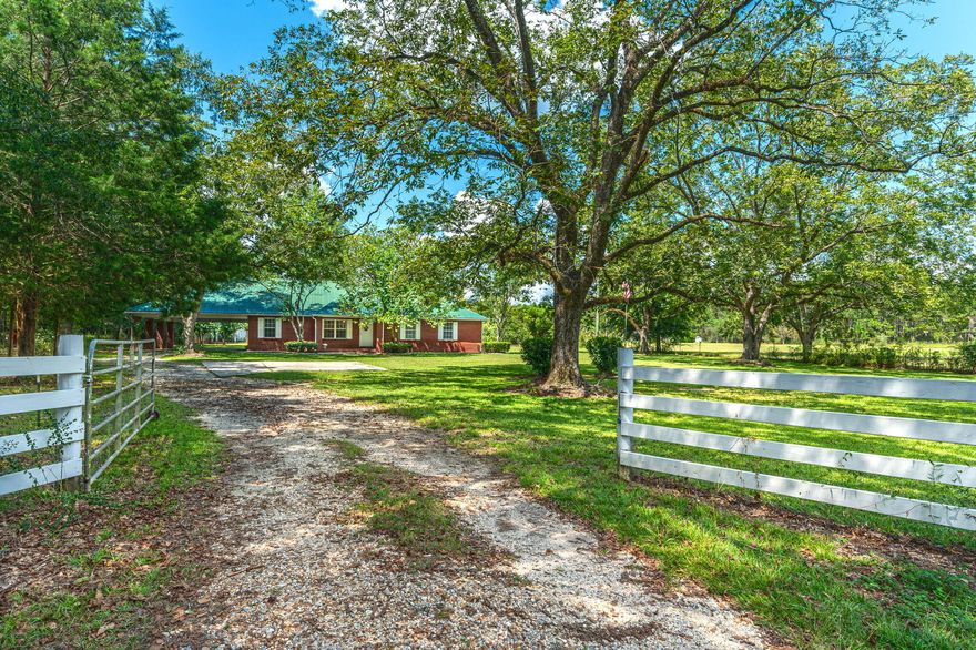 *RARE FIND* Situated perfectly on  5 beautiful acres,this property includes a 4 bay garage (water/electric in place) & additional 30x26 metal barn.Entire property blooms w/greenery and offers mature fruit trees (fig, pear, muscadine, scuppernog, blueberries). The brick home has a gated entrance and is lined w/a white picket fence. Carport easily houses 2 vehicles and connects to massive laundry/storage room w/utility sink. The 400sqft bonus room is accessed here and makes a great movie room or rec space. Many updates done: HVAC 2019,water heater 2021, appliances 2019. This home has been lovingly maintained and feels very spacious. Don't miss your chance to see this country paradise-just 1 hour North of Destin beaches and 10 min South of