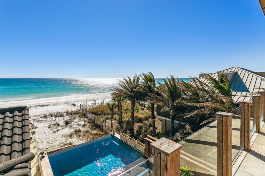 Welcome to luxury - 125' of Gulf front living on Pensacola Beach, fully furnished 6-bedroom, 5-bath beach residence where memories are made strolling the shorelines, relaxing poolside by the infinity pool and marveling at the Blue Angels flying overhead. Meticulously rebuilt from the heartwood studs over two years & completed in 2020, this home seamlessly blends modern opulence with coastal charm. Indulge in panoramic Gulf views while basking in the heated infinity pool or luxuriating in the hot tub. The expansive open floor plan is tailor-made for both gracious living & effortless entertaining. A chef's dream, the kitchen boasts a sprawling marble-topped island accommodating six, complemented by a 48-inch gas cooktop where culinary magic unfolds. Distinguished by honed superlative marble countertops, the kitchen exudes both functionality & elegance, harmonizing with the monochromatic neutral palette of the living space, adorned with shiplap wood planks for a cozy coastal texture. The primary bedroom, thoughtfully positioned to overlook the Gulf & infinity pool, invites serenity through sliding glass doors leading to the wrap-around porch. Pamper yourself in the primary ensuite bath featuring a spacious travertine-clad shower, double vanity, & a meticulously organized walk-in closet. A vast three-car garage with 10-foot-tall doors & ample storage space accommodates outdoor essentials, including oversized trucks or boats, with ease. Head to the pool "tower room," a haven of guest luxury boasting an ensuite bath & a Juliet balcony offering breathtaking views of both the heated infinity pool & the Gulf of Mexico, a spectacle especially captivating during Blue Angels displays. Added in 2020, this pool house with a separate entrance ensures privacy for guests. Completely turnkey - This home is ready for you to call the beach your home or utilize this amazing opportunity for an exceptional income producer.  Some furnishings being changed out & new added.  BEING SOLD AS IS