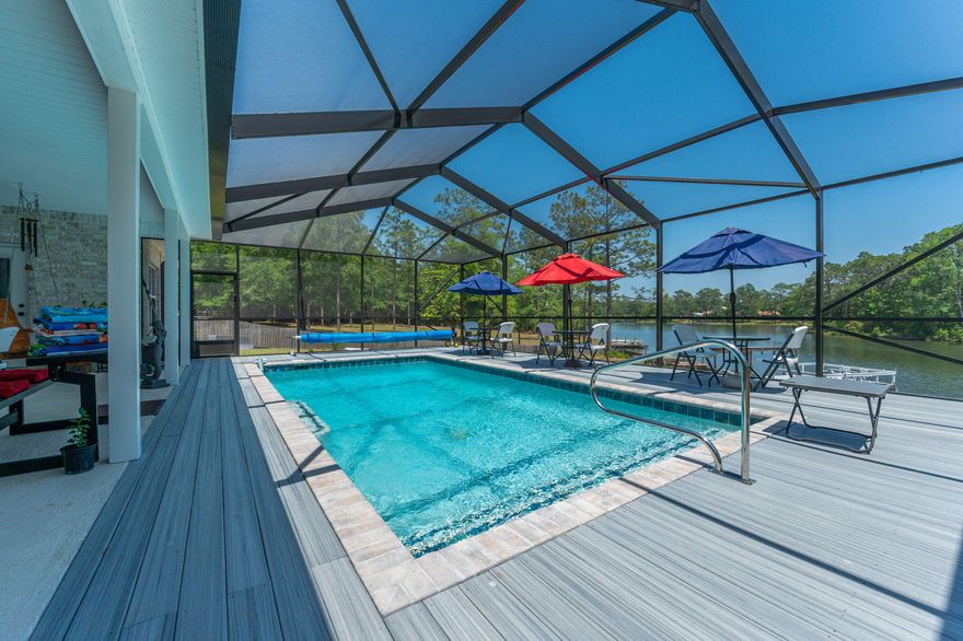 This custom home has ALL OF THE THINGS! Open floorplan and split bedrooms.  The kitchen is a dream come true with an abundance of cabinets, Corian counter tops, Italian stone on the front of the oversized bar and a walk-in pantry. The other features include  tile flooring throughout, Italian stone fireplace, special ordered light fixtures, floor to ceiling tiled showers in all 3 bathrooms, pocket doors, gas fireplace with remote, plantation shutters, marble window sills & the list goes on. The master suite has his & her walk-in closets. The living room opens up to the lanai and the heated saltwater screened-in pool surrounded by a Trex deck overlooking the lake! Over-sized 15x20 dock is perfect to fish from & the bass are biting! Plus there is a 12x32 storage and full RV hook up